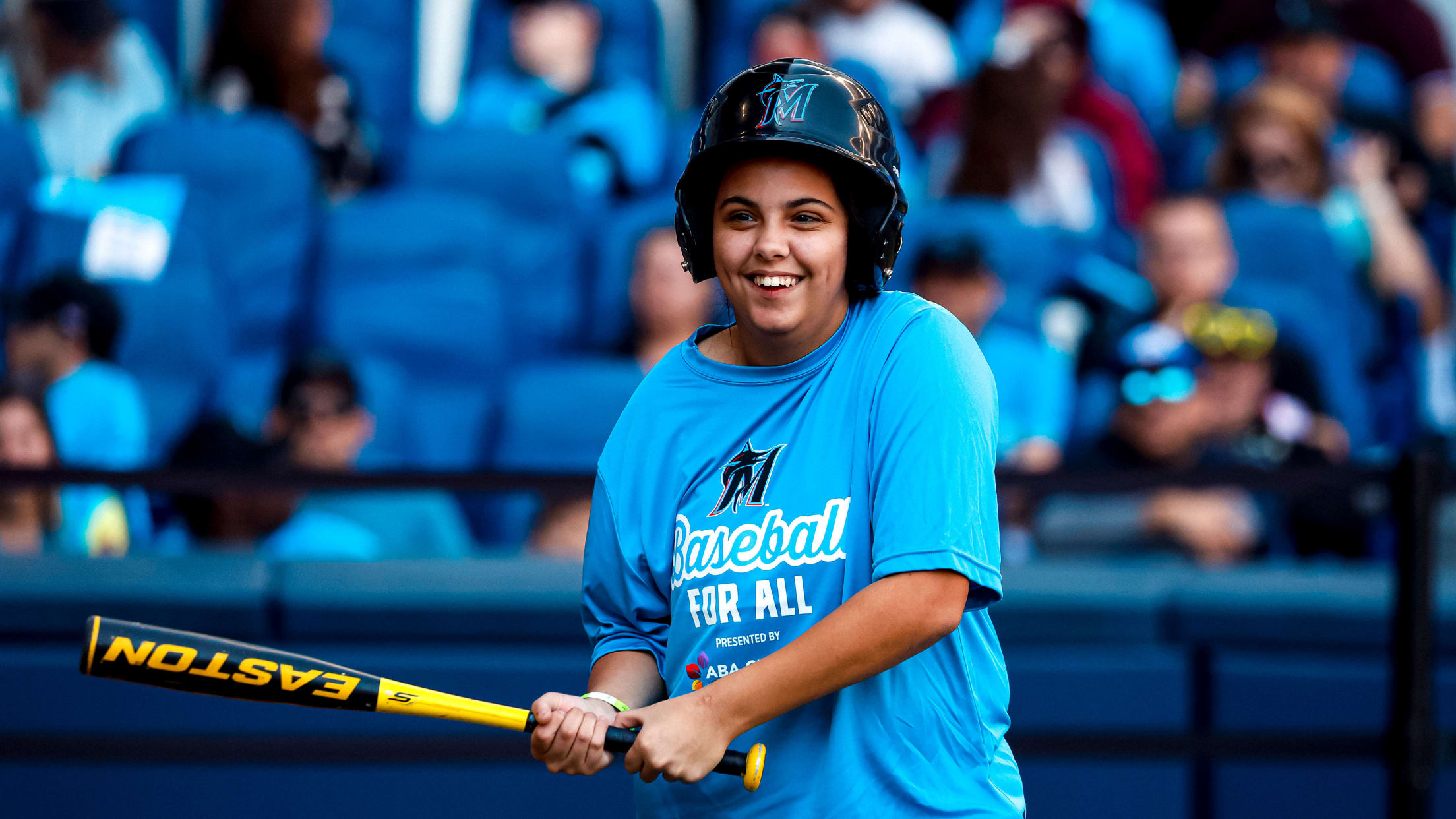 A Marlins Youth Academy athlete stands with a bat.