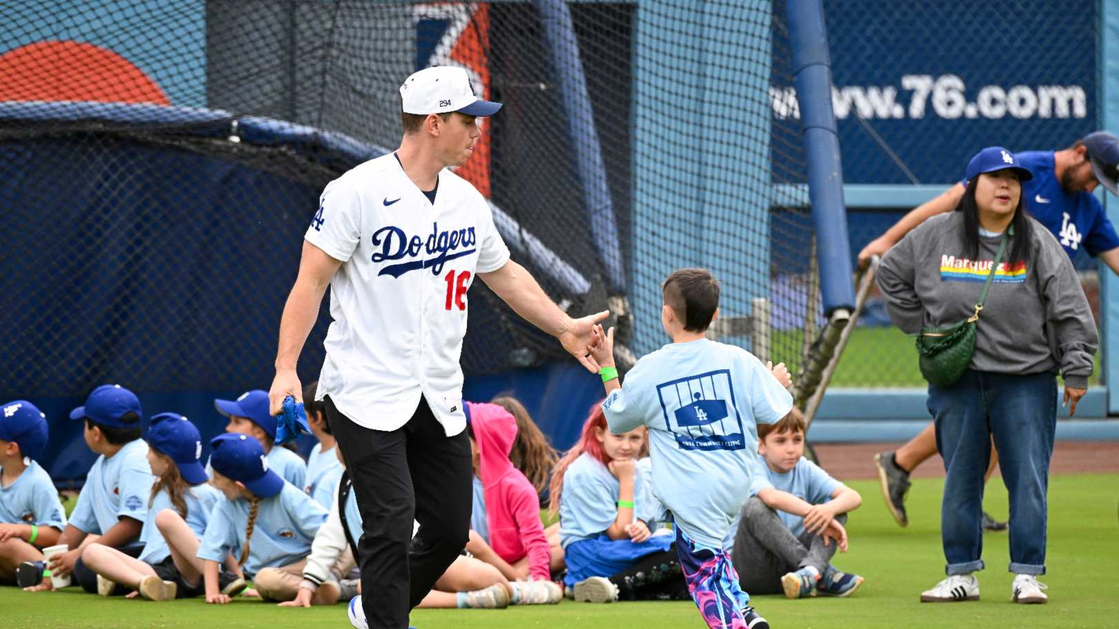Will Smith high fives a kids as he runs on the field at Dodger Stadium.