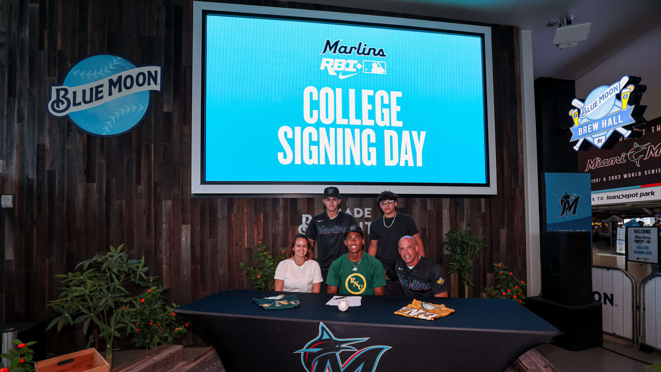 A young player poses for a photo with his family at the Marlins Nike RBI College Signing Day.