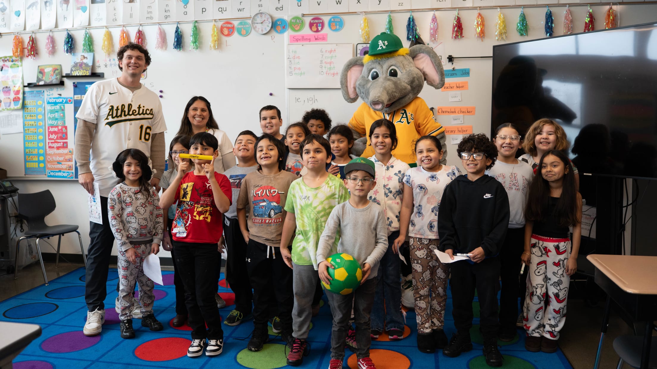 Nick Kurtz, Stomper and children pose in a classroom.