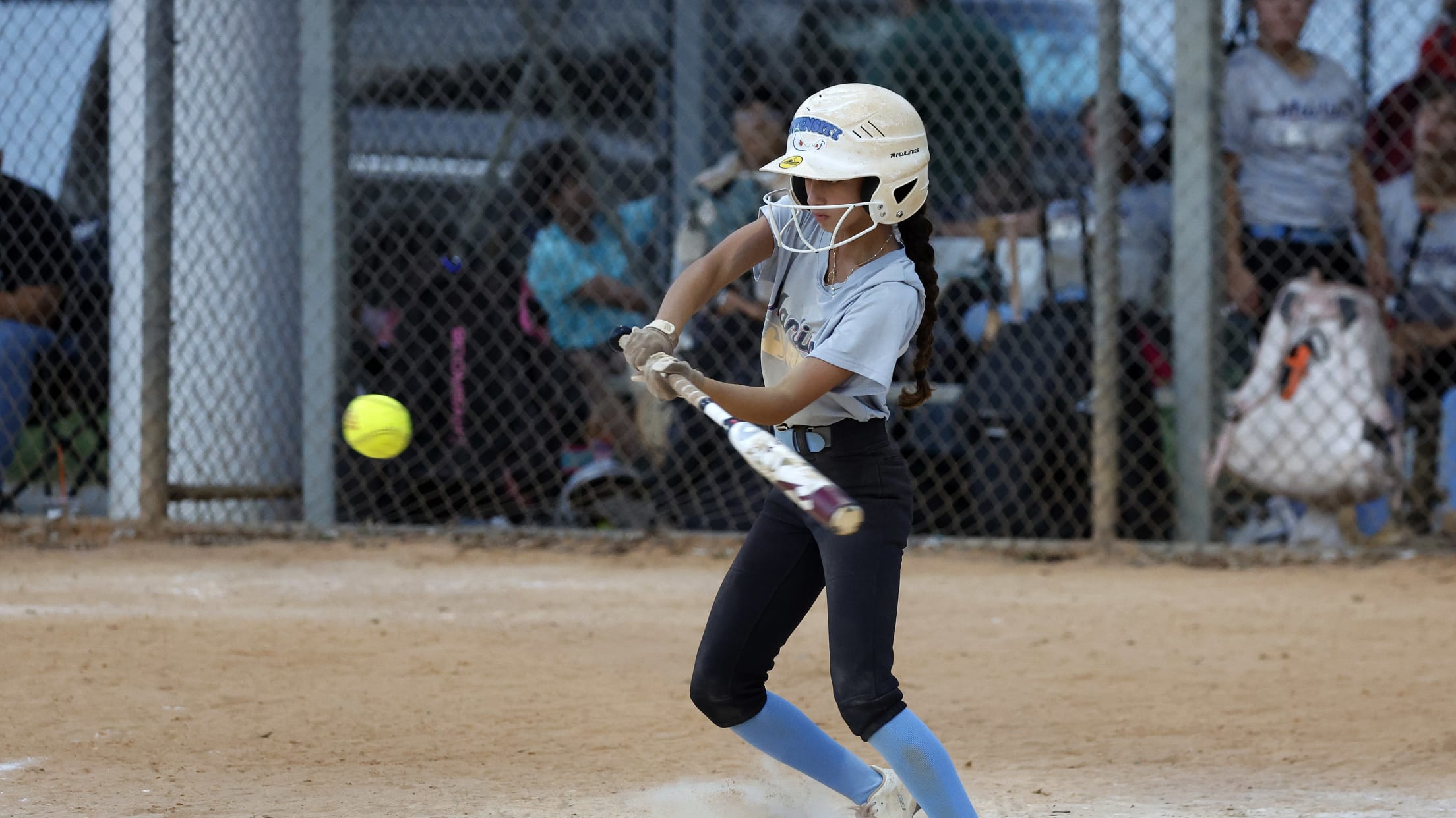 A young batter swings at the pitch during the Marlins Nike RBI Softball Classic.