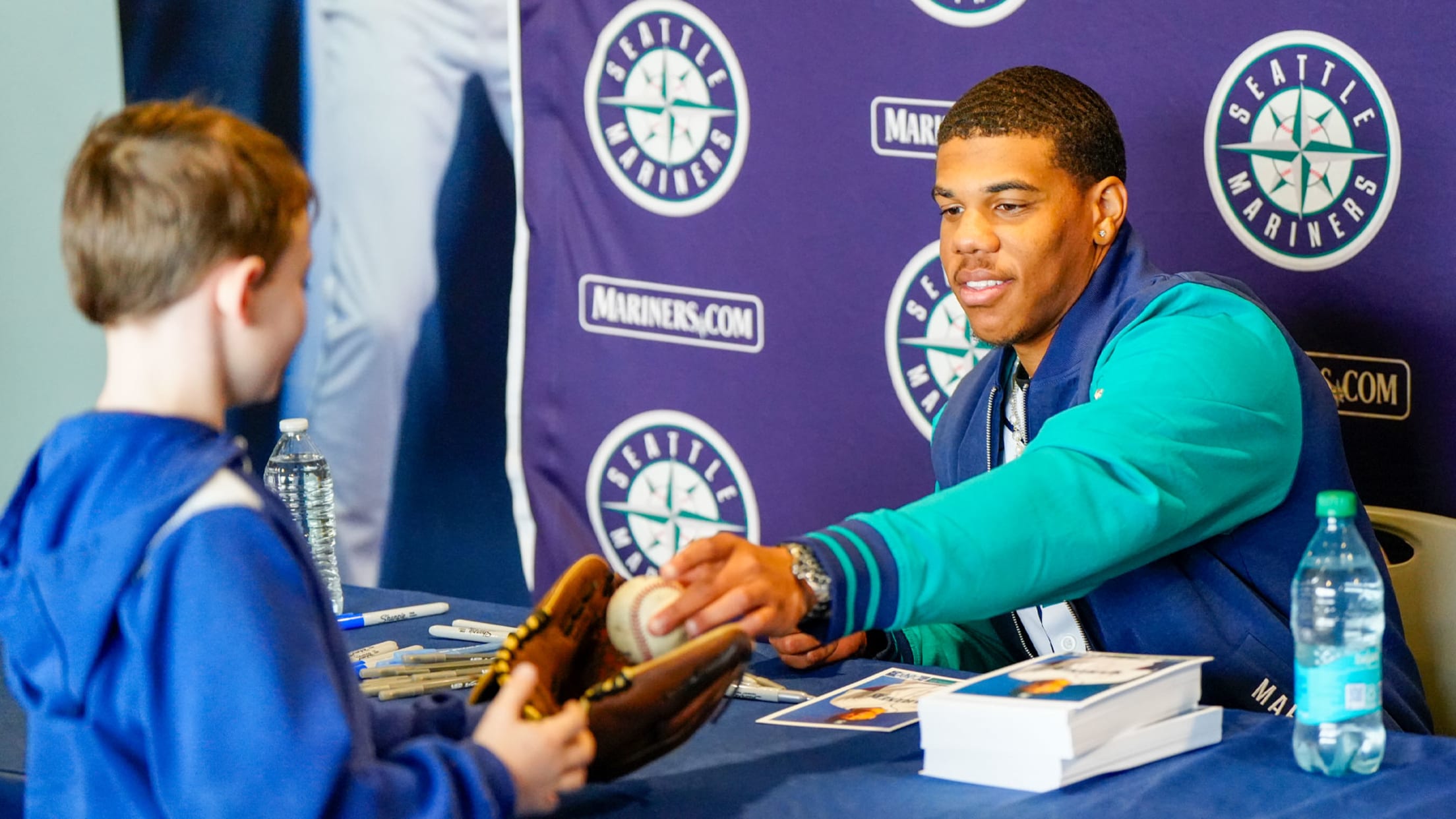 Image of Jurrangelo Cijntje signing autograph for young fan.