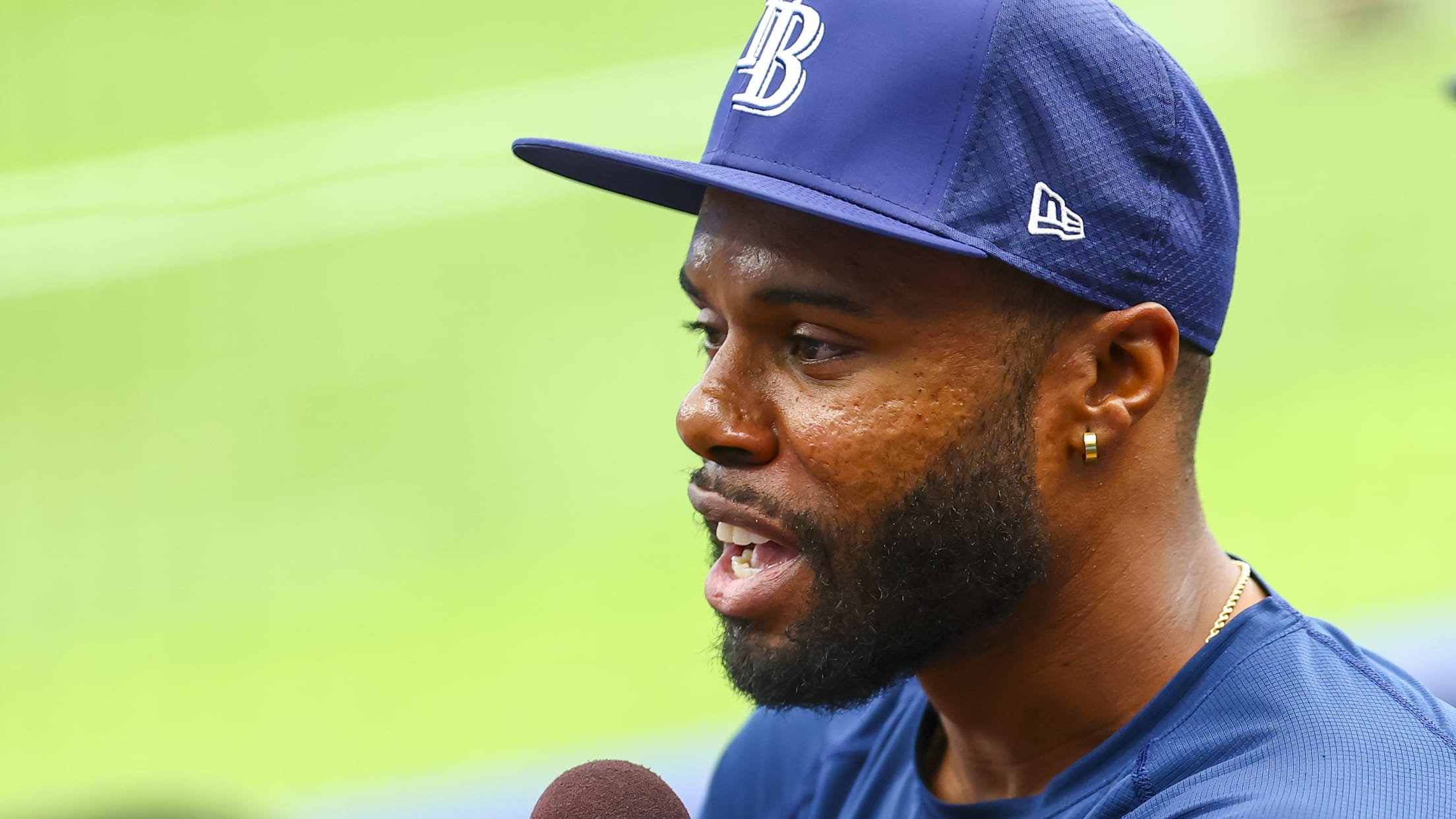 Cedric Mullins holds a microphone while participating in an interview.