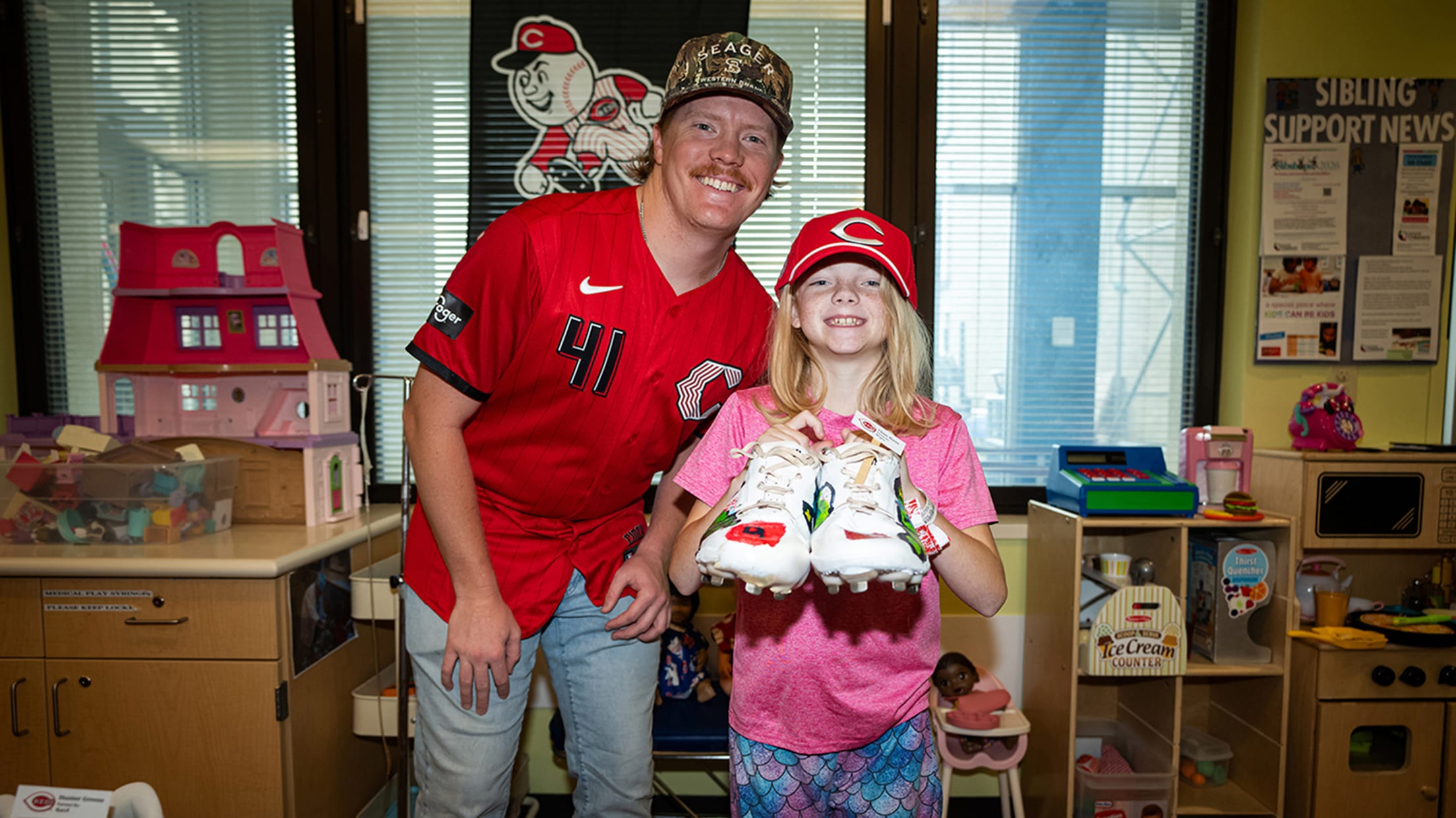 Andrew Abbott with one of the Cincinnati Children's Hospital patients holding the cleats she painted.