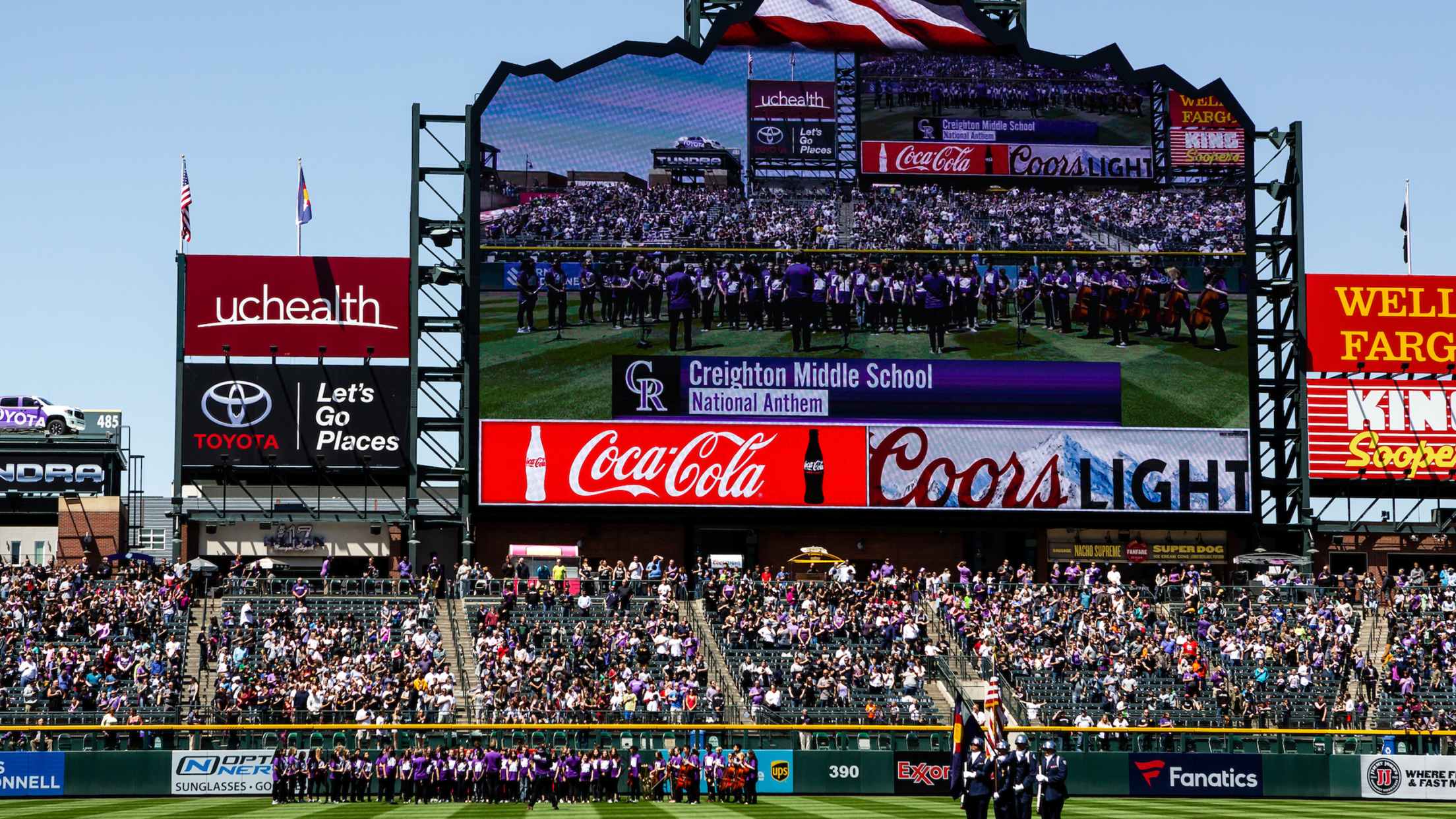 Pregame national anthem ceremony at Coors Field with the school singing on the scoreboard