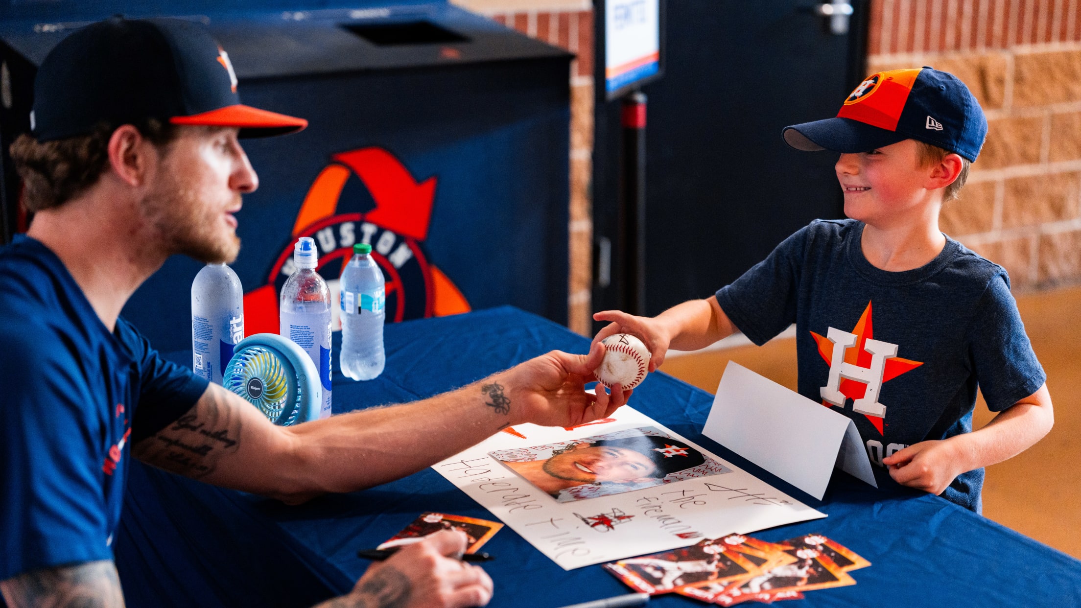 Josh Hader interacts with a young fan as he signs a baseball.