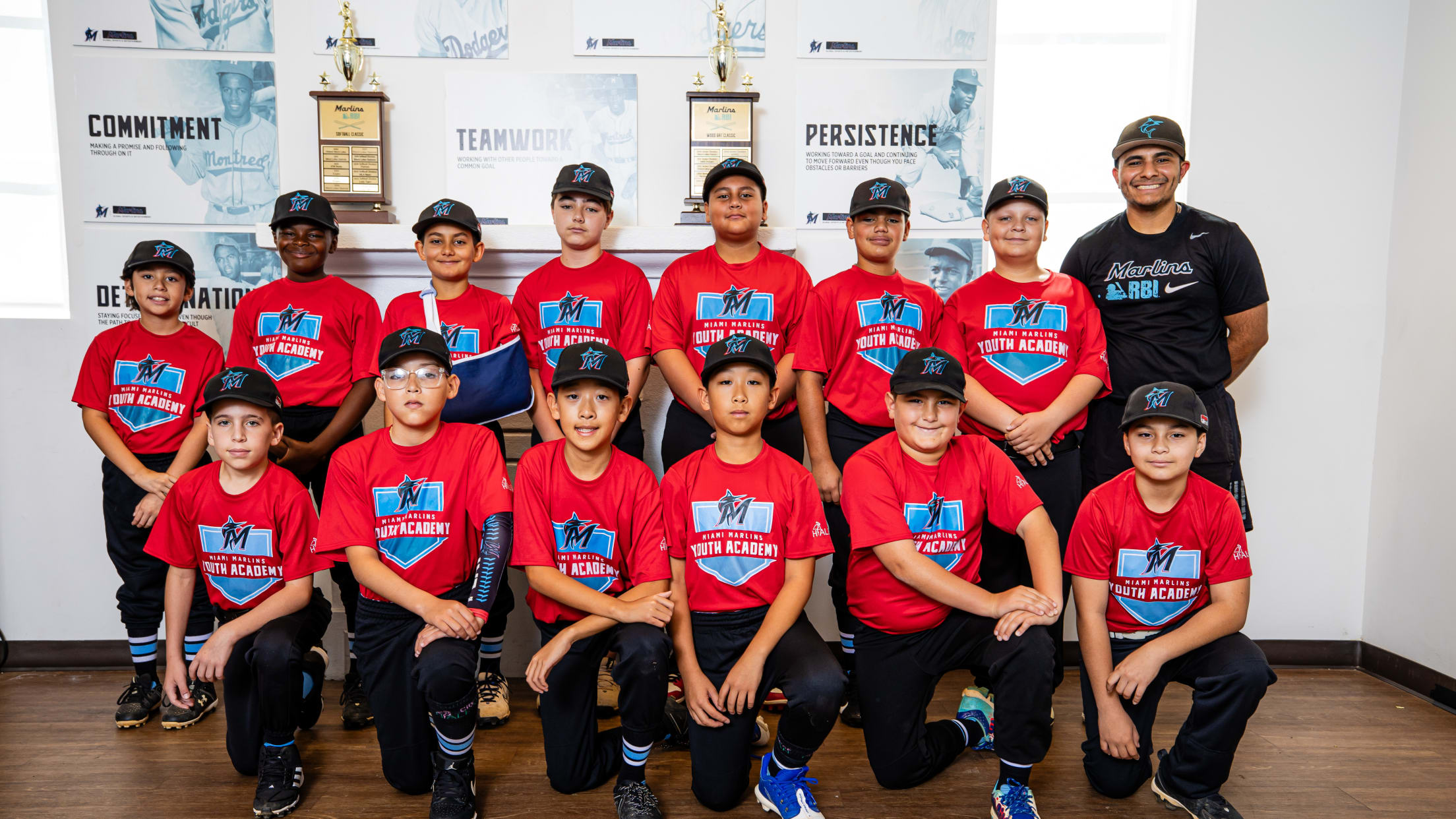 Players and a coach from Marlins Youth Academy take a team photo.