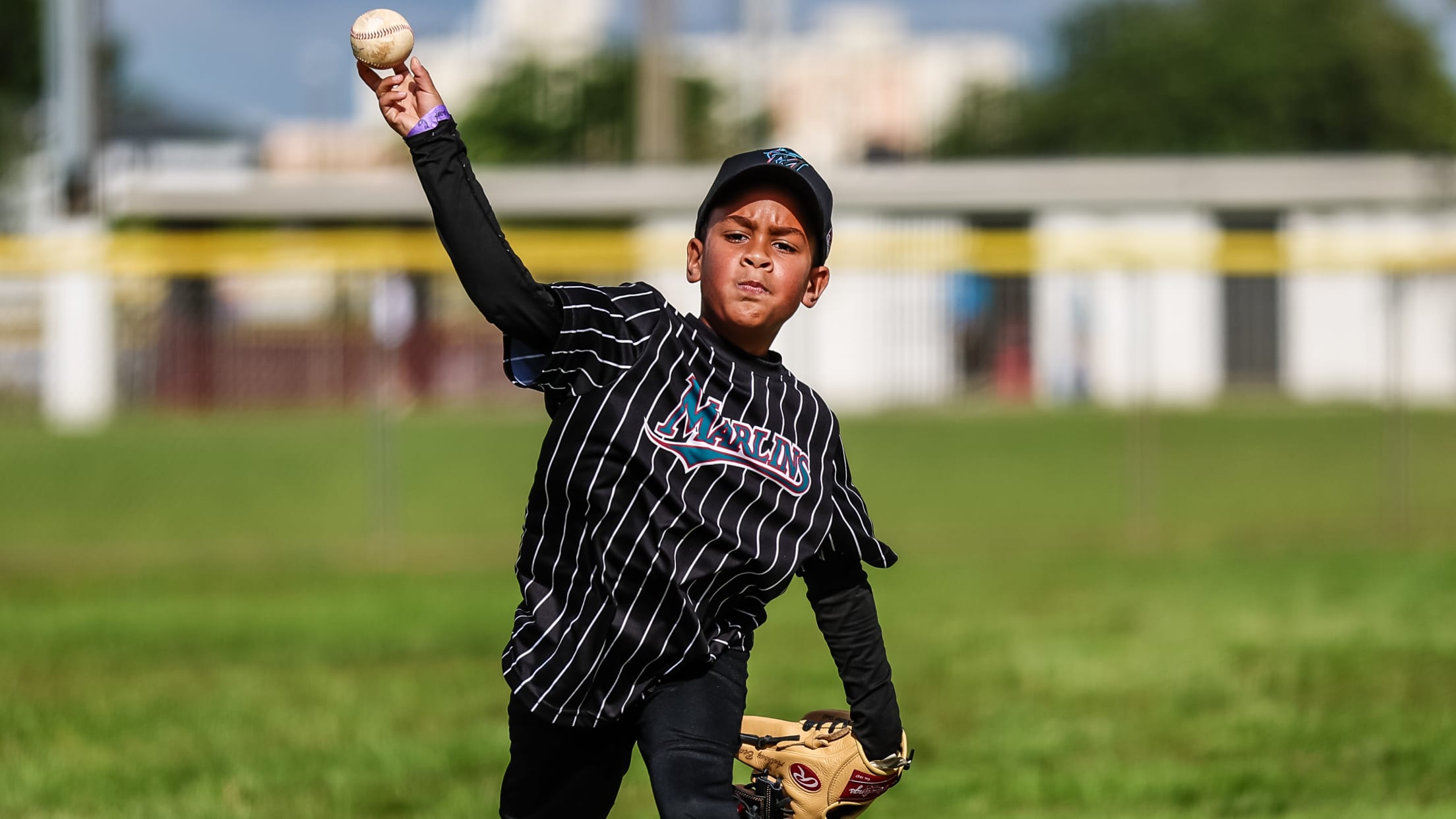 A young player throws the ball at MLB Pitch, Hit and Run.