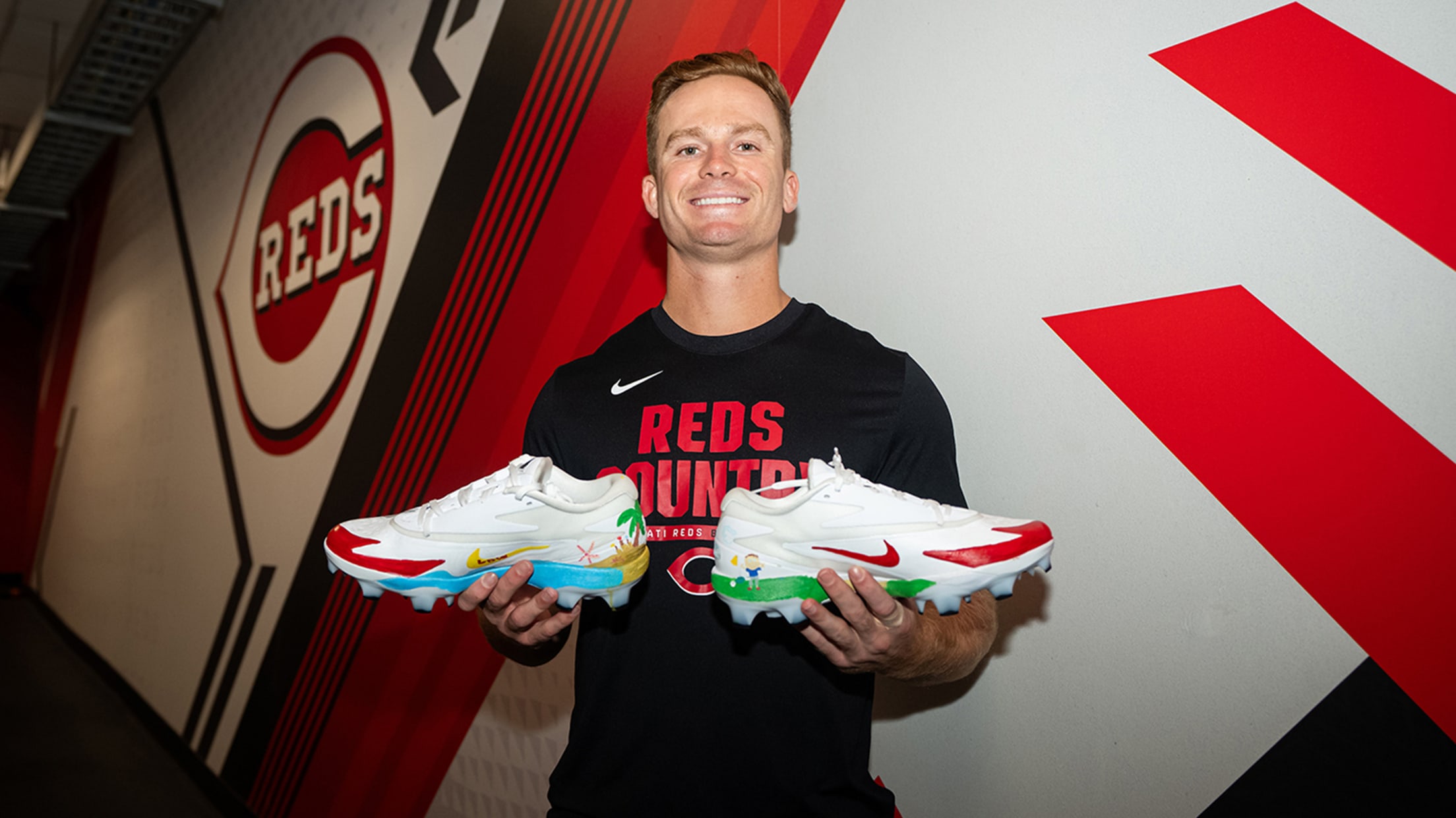 Matt McLain smiles with his beach and golf-themed cleats.