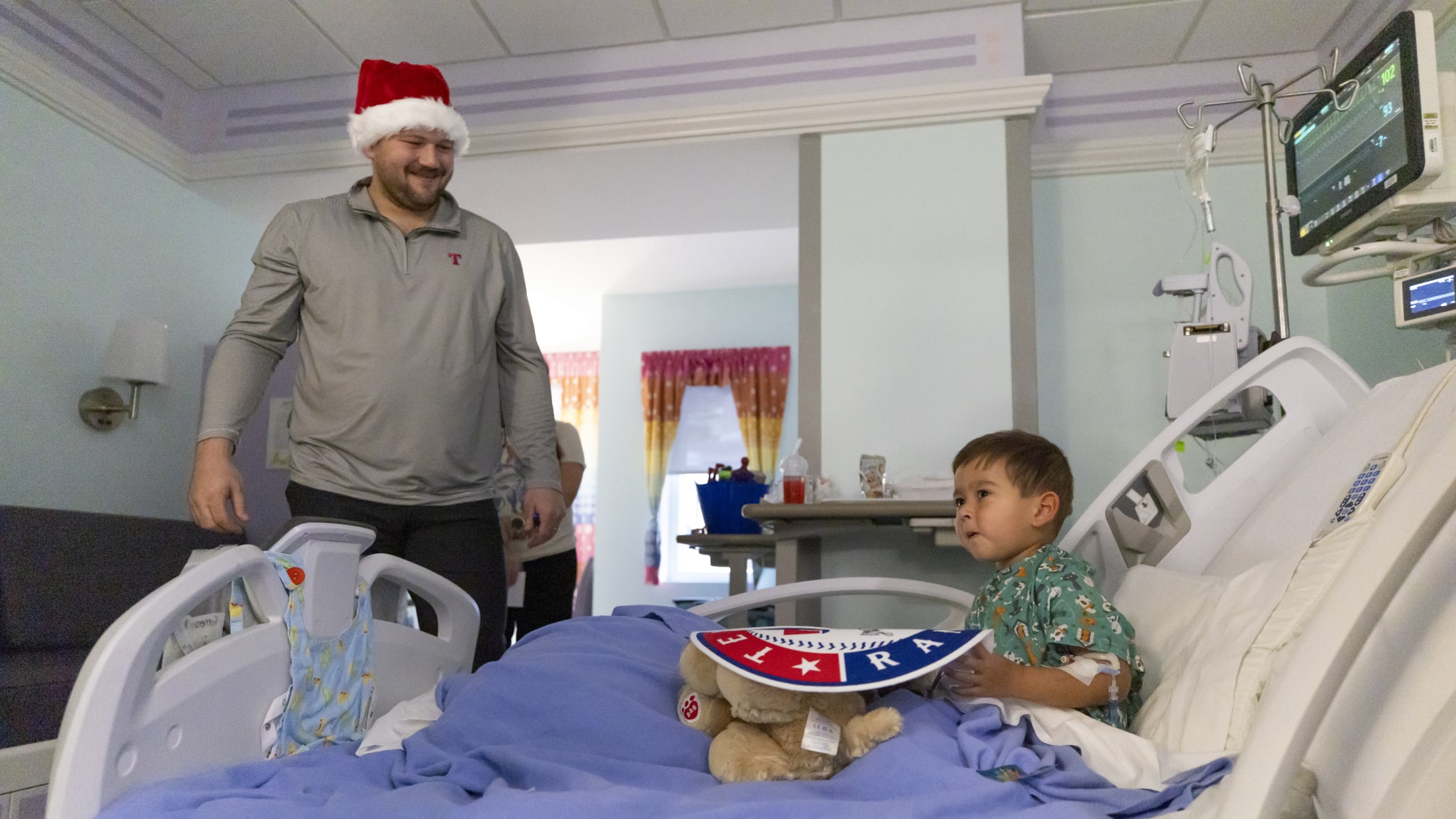 Jake Burger visits a young Texas Rangers fan at the hospital.