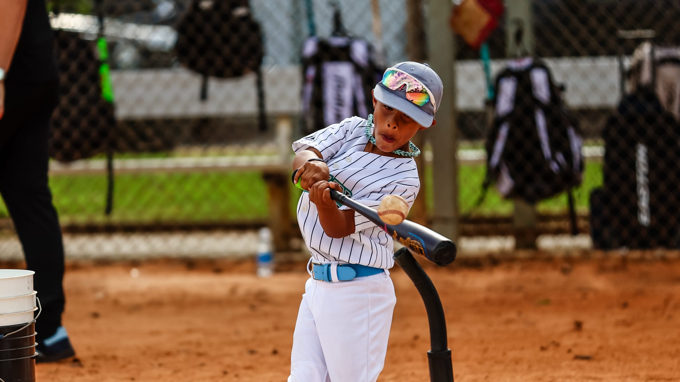 The batter swings and connects with the ball off a tee at MLB Pitch, Hit and Run.