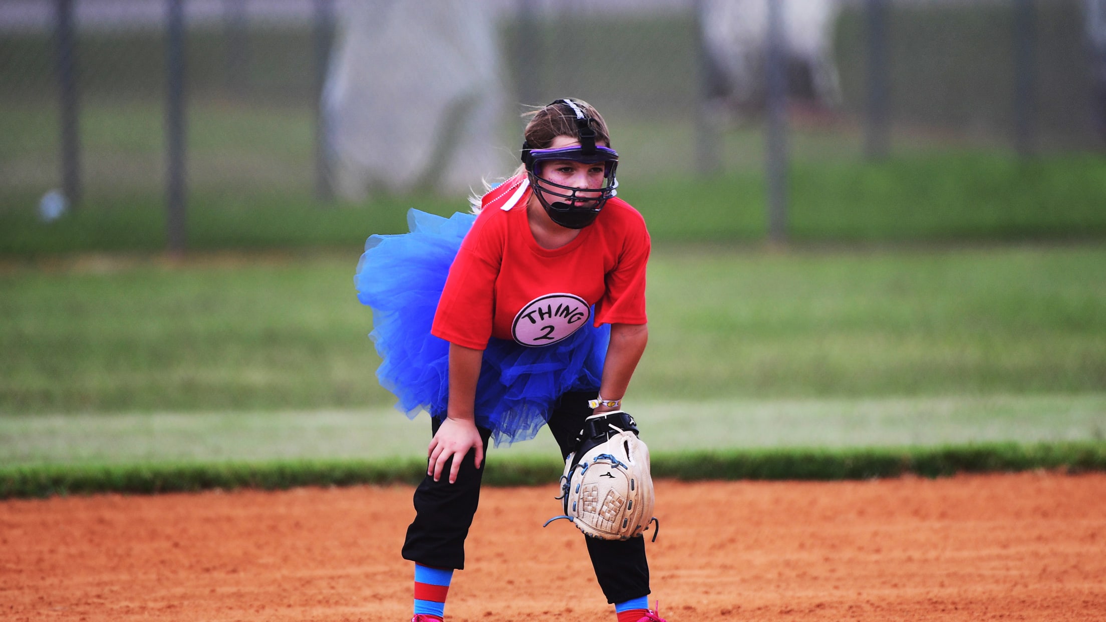A youth softball player on the field dressed in their Halloween costume,