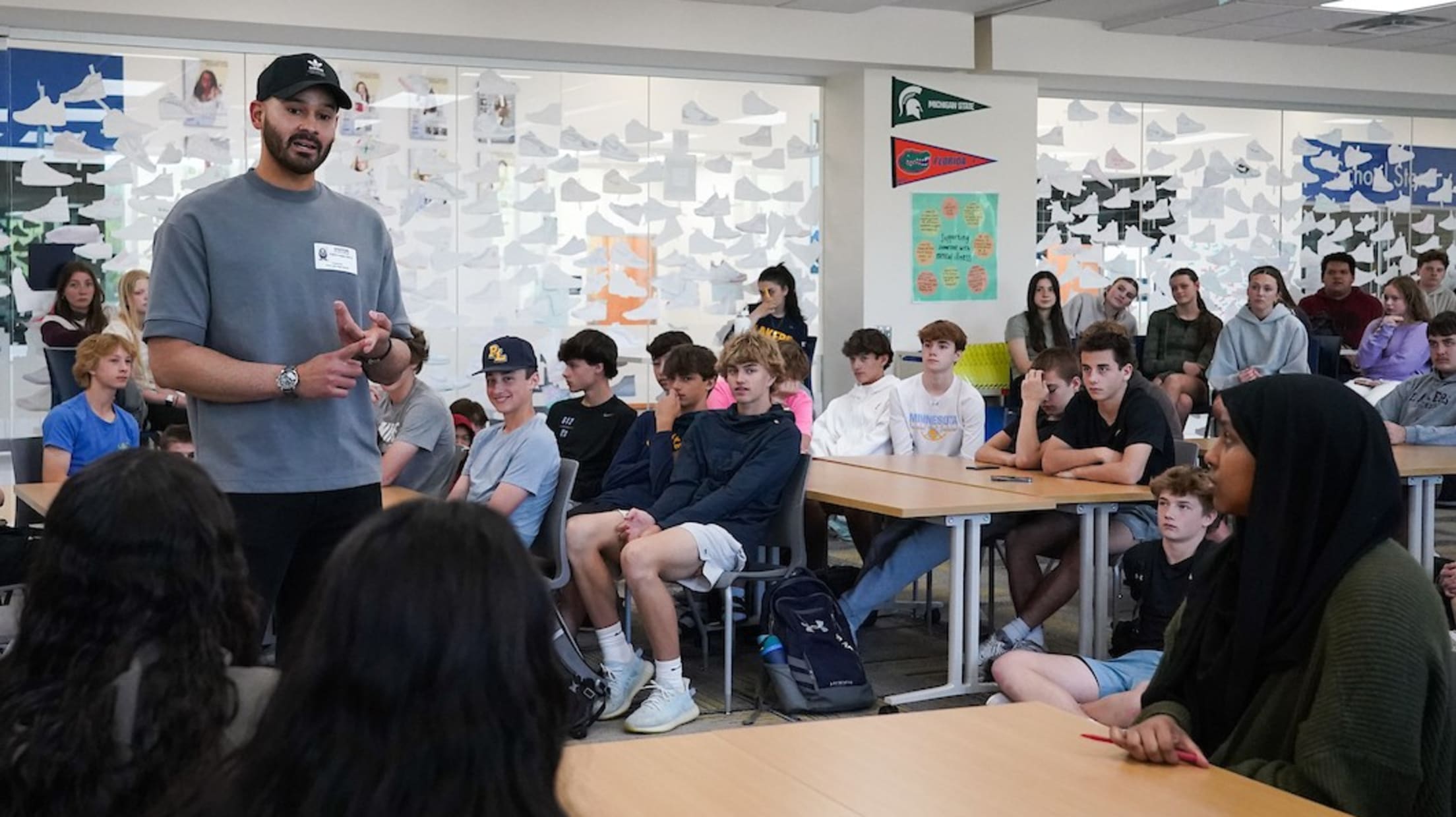 Pablo López speaks with students at a high school.