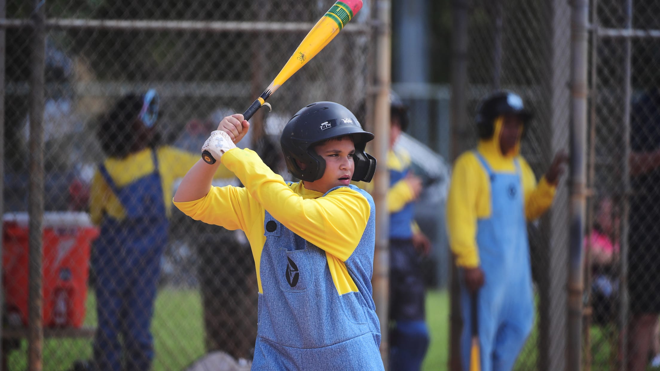 A player dressed as a minion stands in the batter's box.