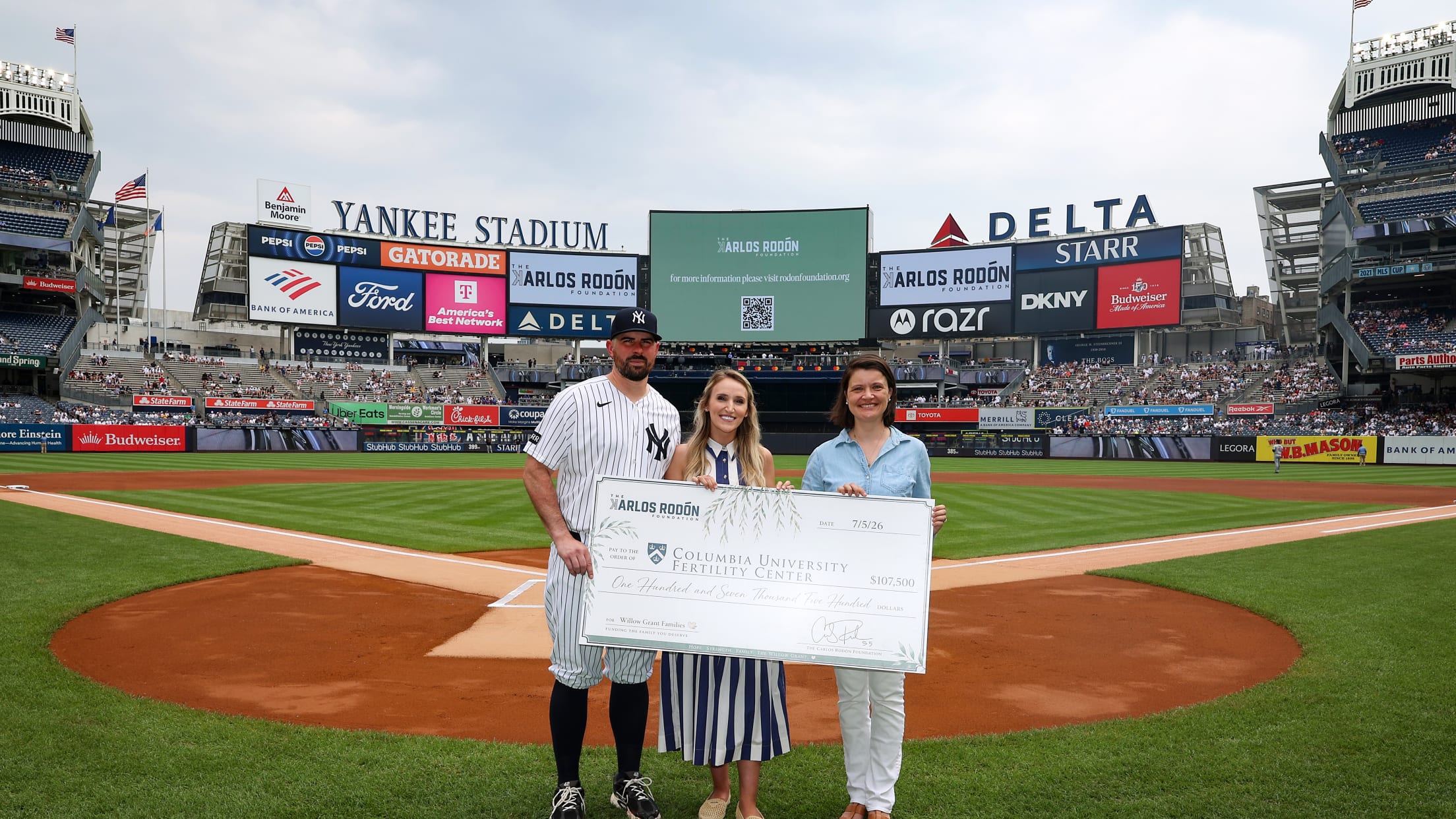 Carlos Rodón and Ashley Rodón pose with a check issued by the Carlos Rodón Foundation to Columbia University.