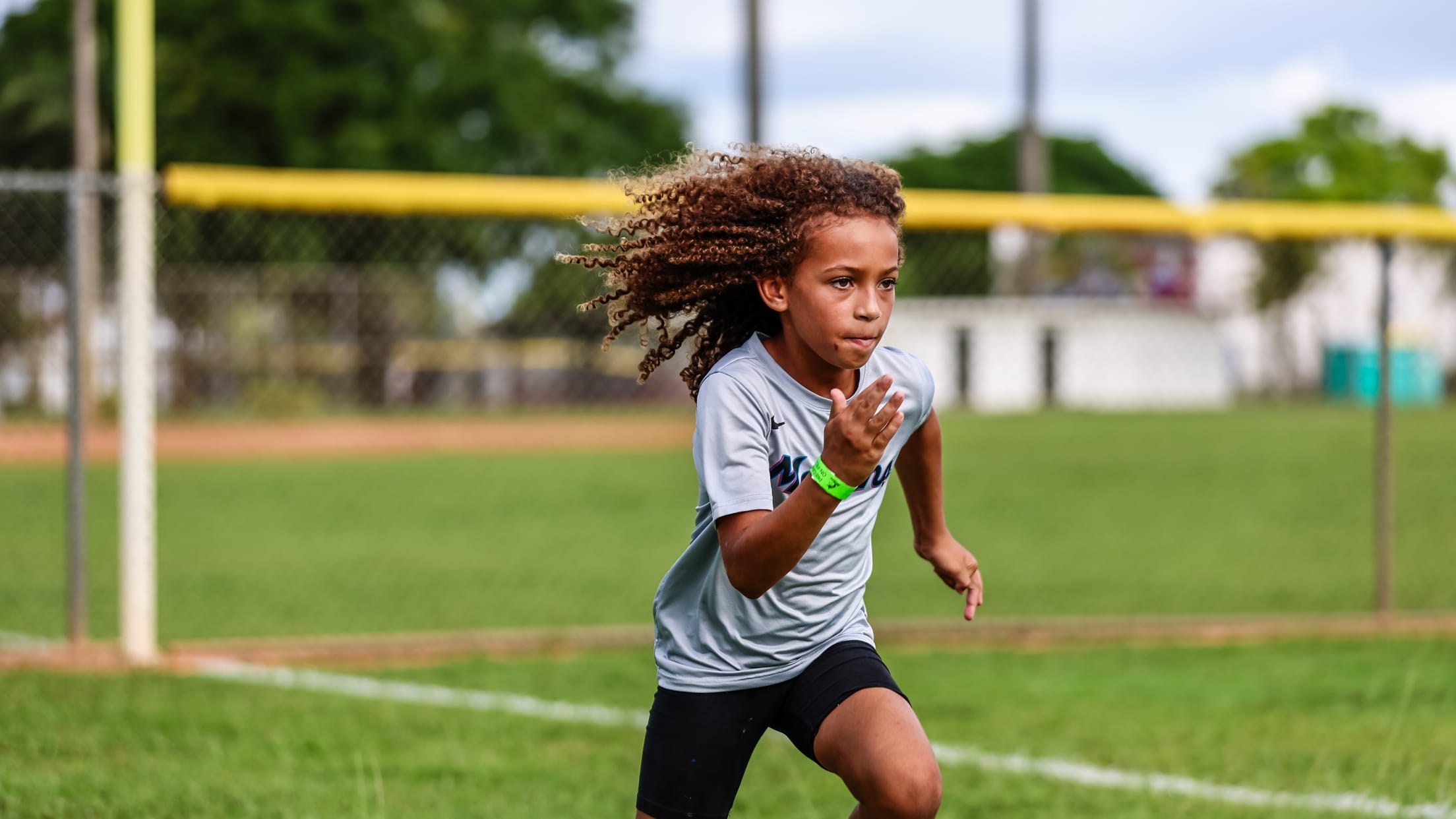 A young player runs down the outfield line.