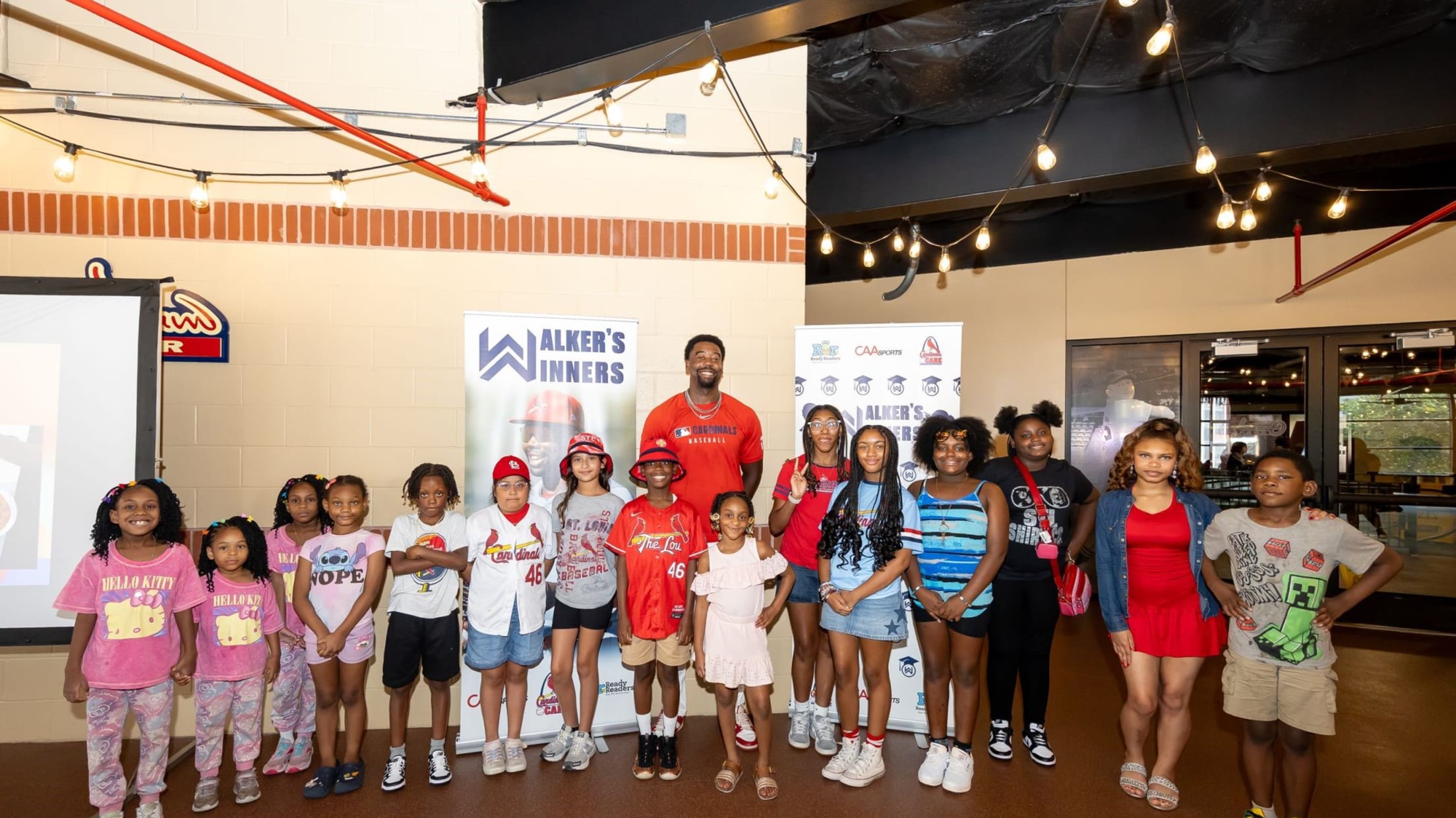 Jordan Walker takes a photo with a group of kids at a Walker's Winner's event.