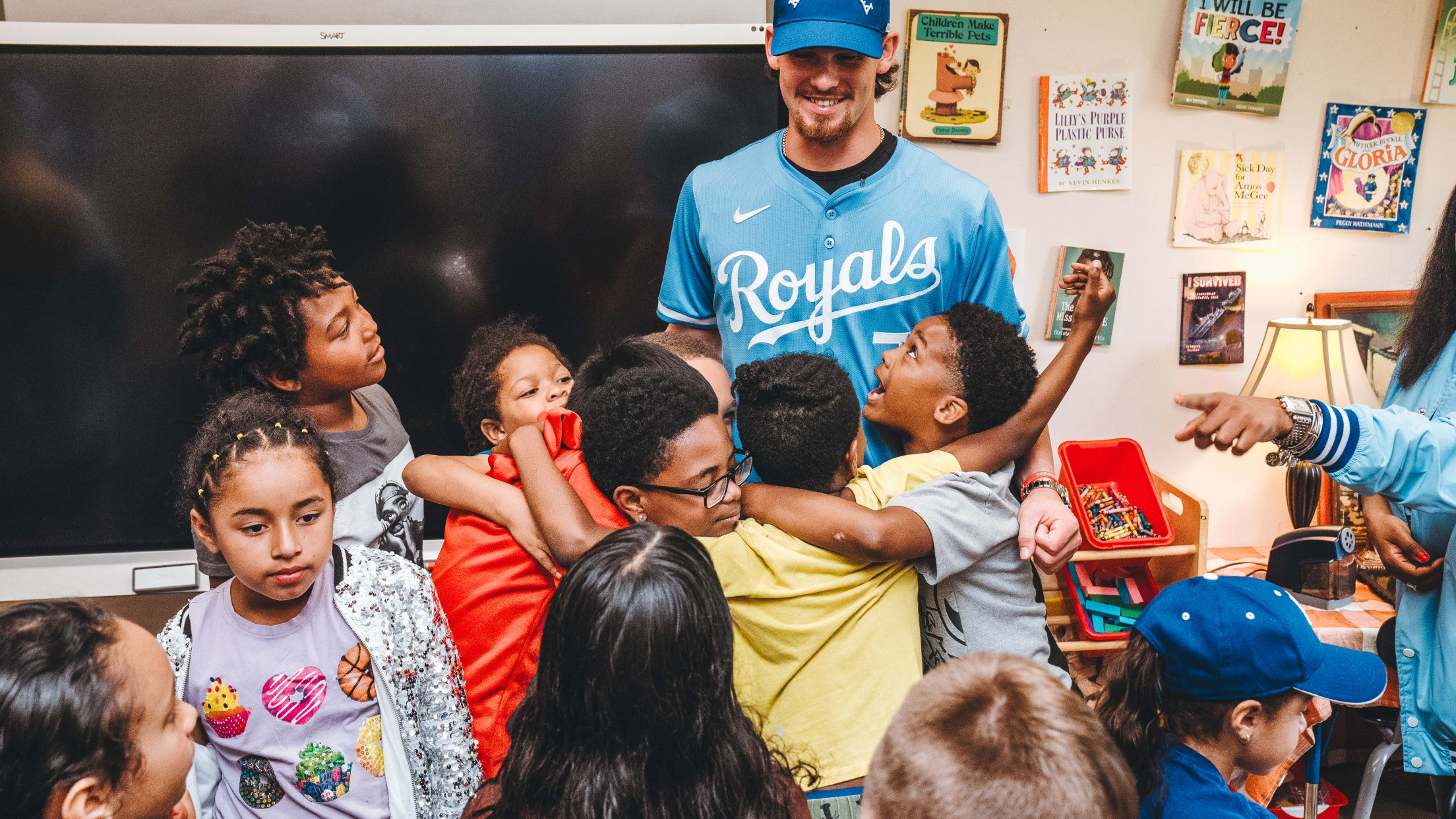 Bobby Witt Jr. gets a hug from students at Ingels Elementary School as their classroom champion for the Royals Literacy League initiative.