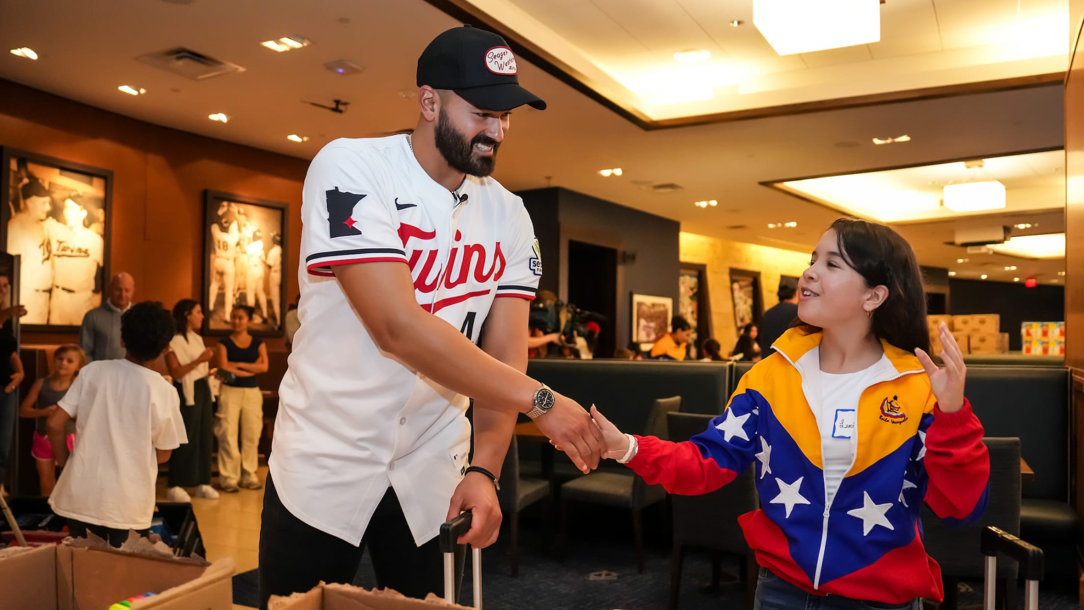 Pablo López shakes hands with a fan as they attend a school supply event.