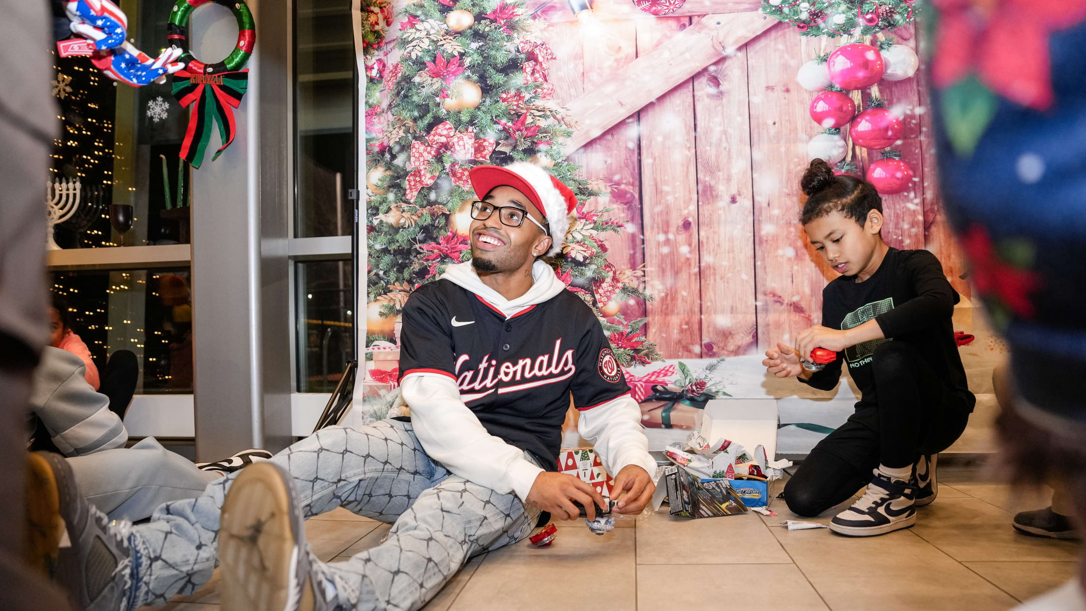 Nasim Nuñez and a young child play with toys at the Nationals Baseball Academy gift drive.