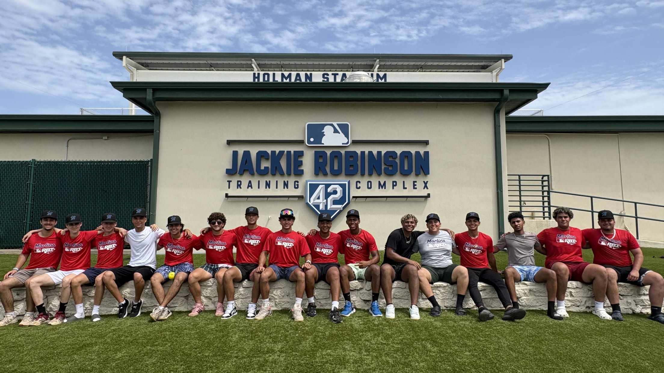 A group of players take a photo outside the Jackie Robinson Training Complex's Holman Stadium.