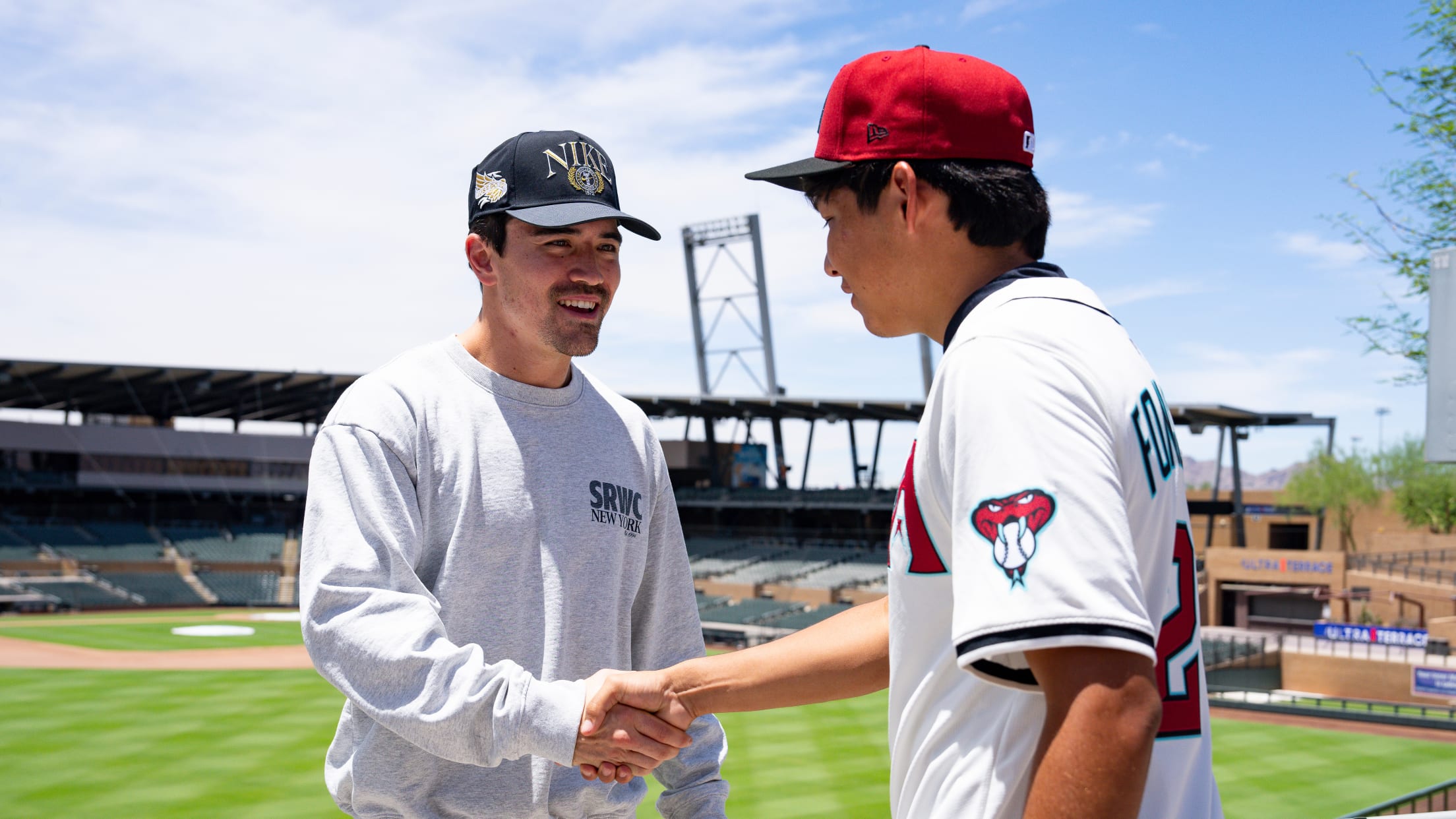 Corbin Carroll shakes hands with a fan at an event with Nike RBI.