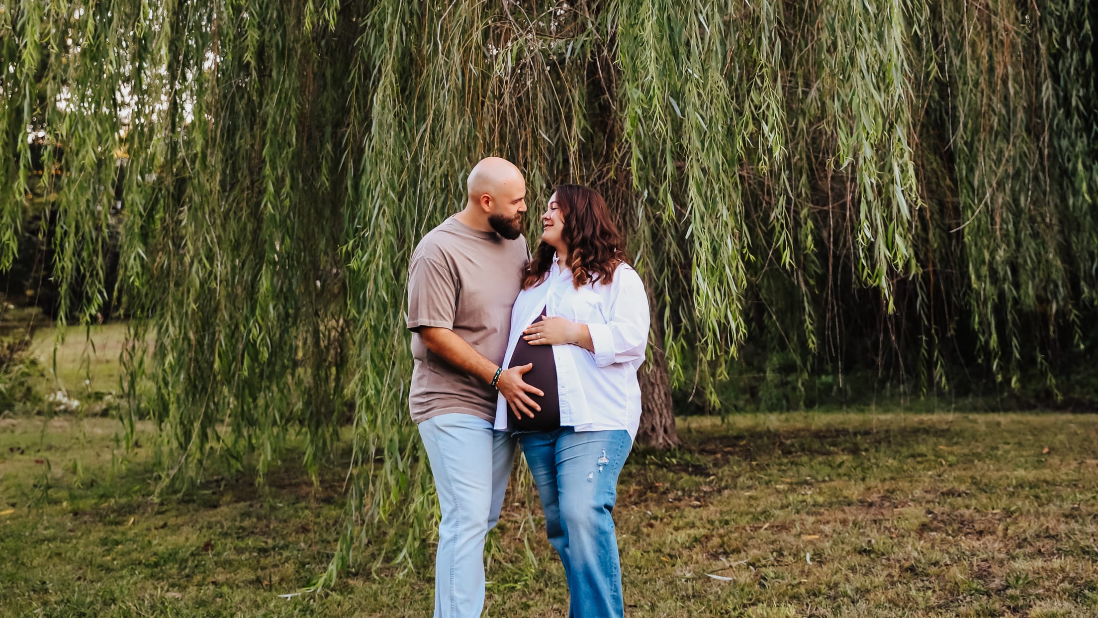A man and woman take a pregnancy photo.