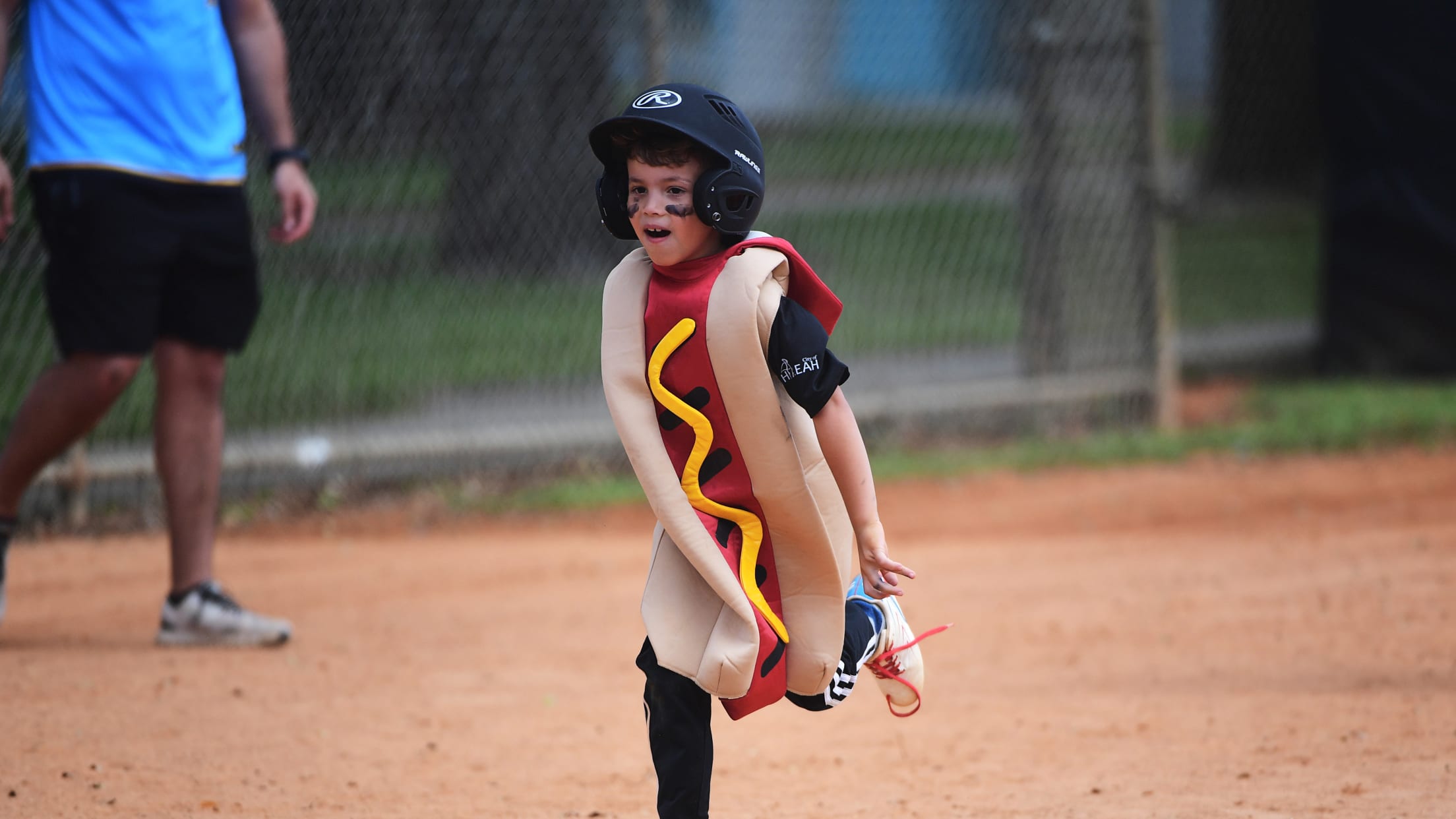 A player runs along the baseline in a hot dog costume.