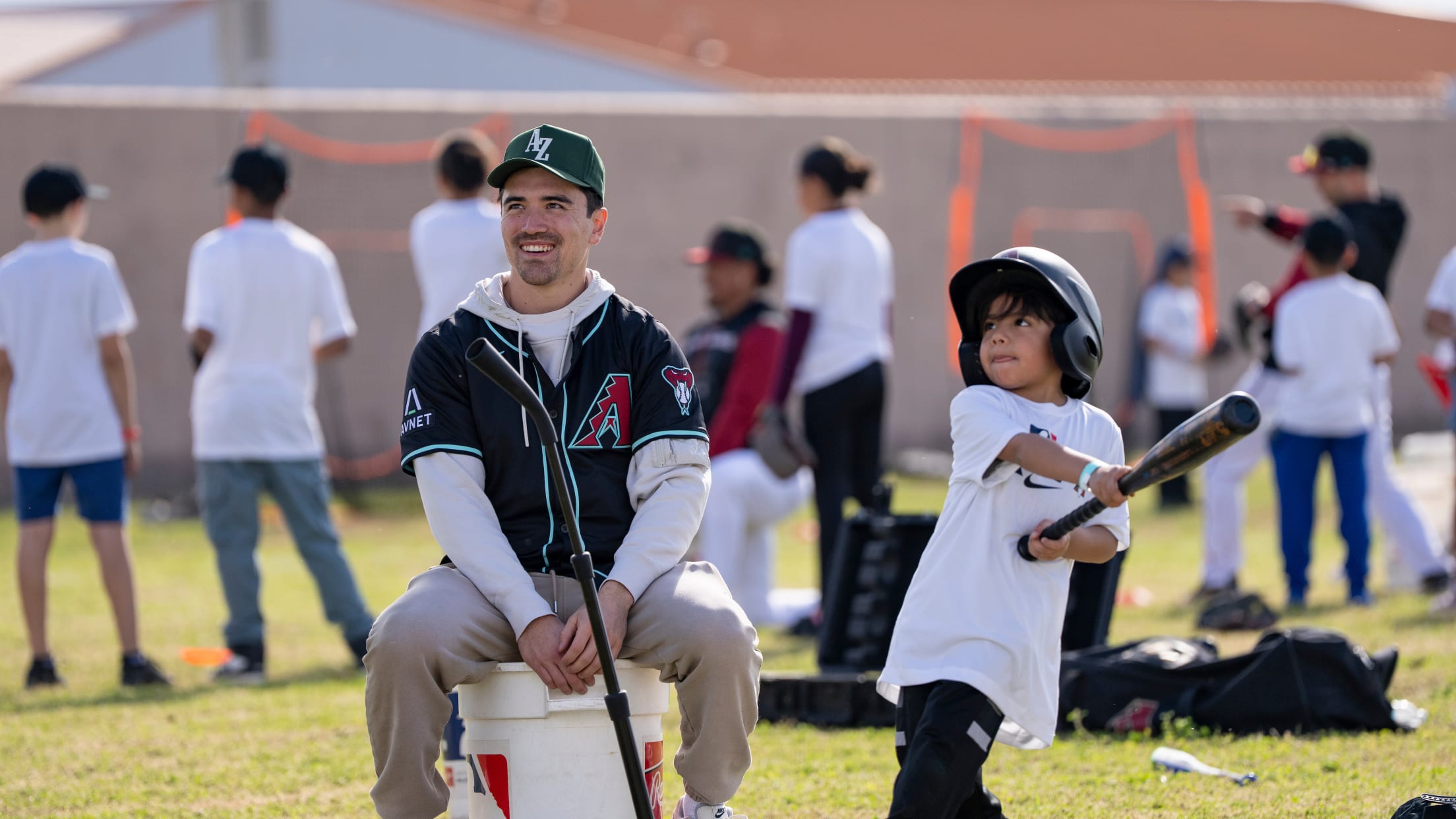 Corbin Carroll watches a young player hit the ball at a Nike Jr. RBI event.