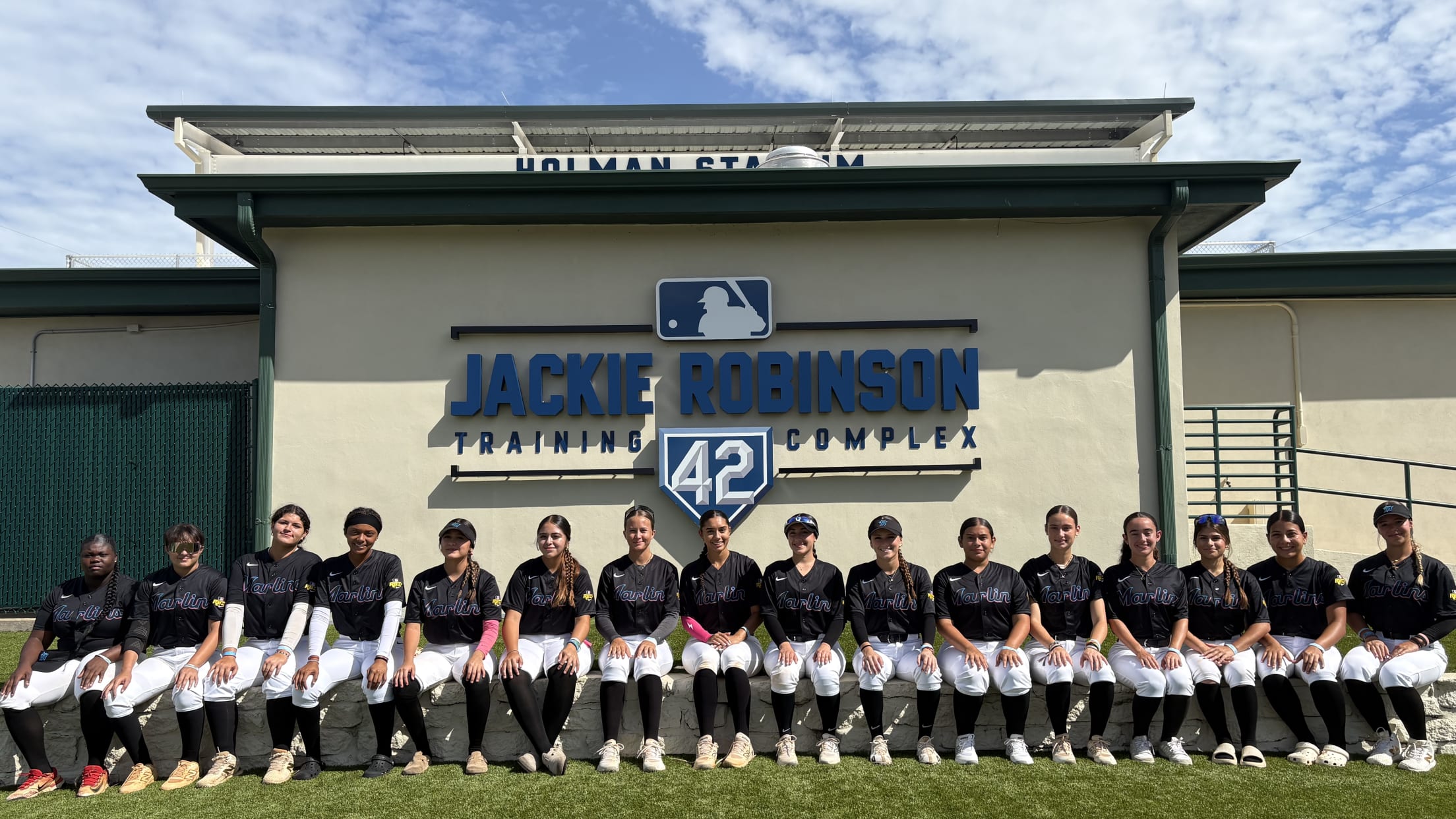 Players pose for a team photo while sitting outside Holman Stadium at the Jackie Robinson Training Complex.