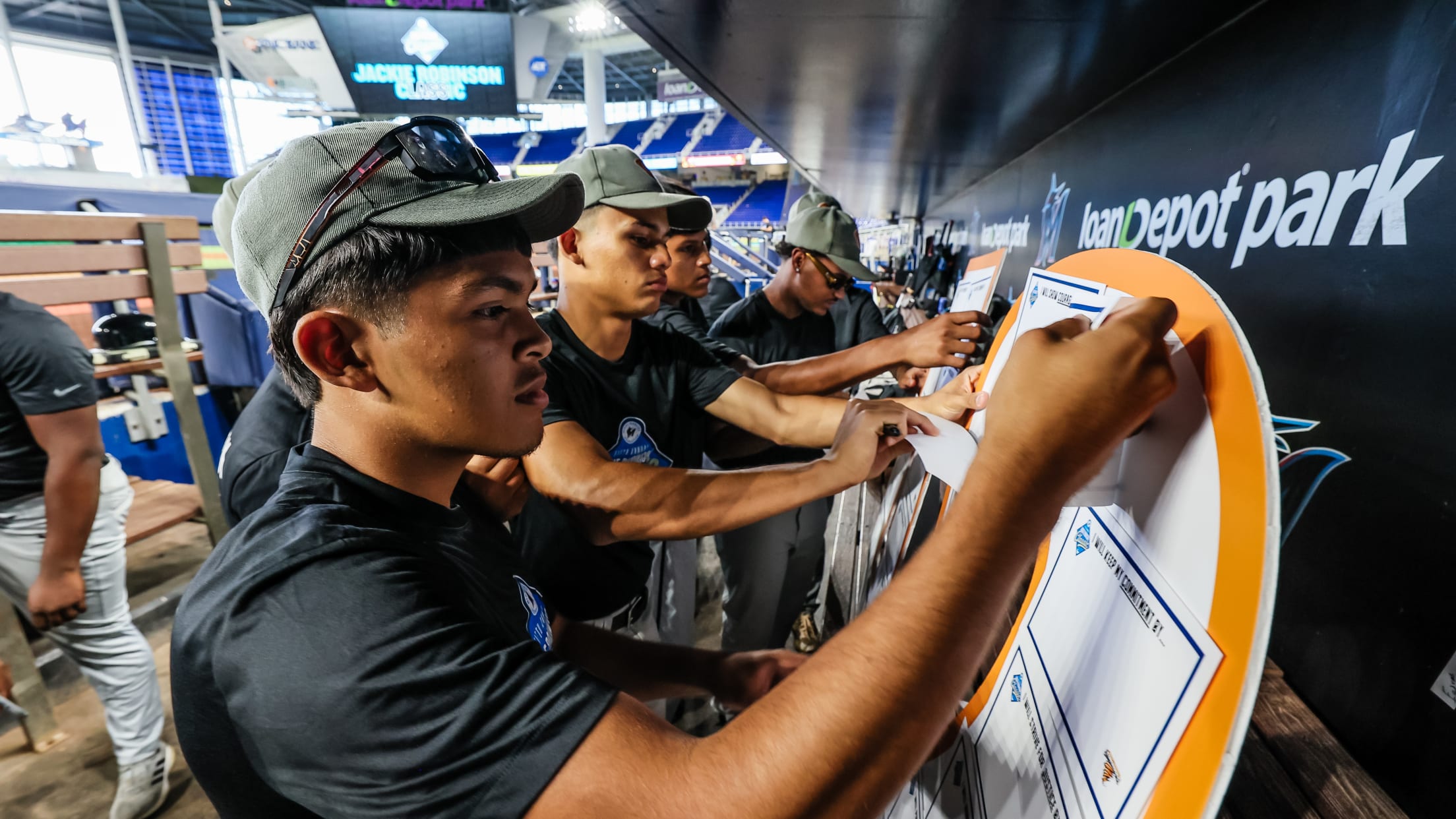 Players gather round in the dugout at the Jackie Robinson Classic.