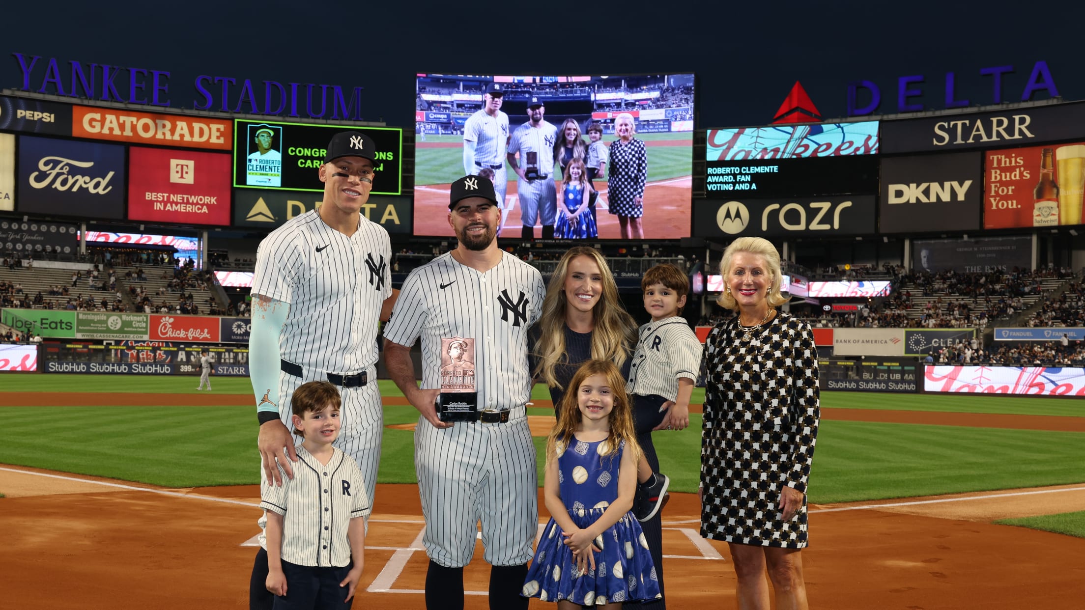 Aaron Judge, Carlos Rodón and others pose for a photo behind home plate at Yankee Stadium.