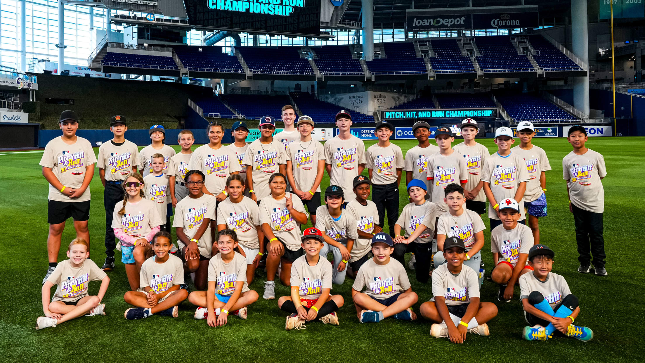 Marlins Youth Academy athletes pose for a photo on a field after the Pitch, Hit and Run championship.