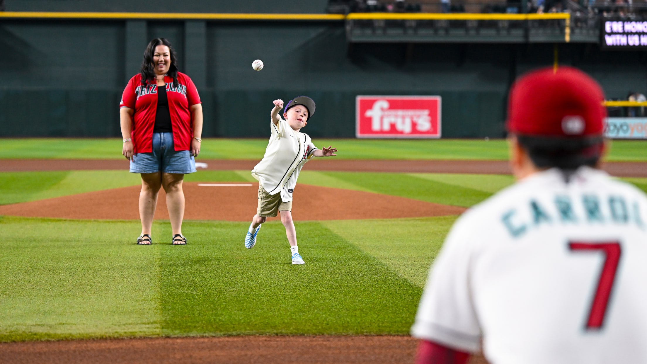 A young fan tosses the first pitch to Corbin Carroll during pregame ceremonies.