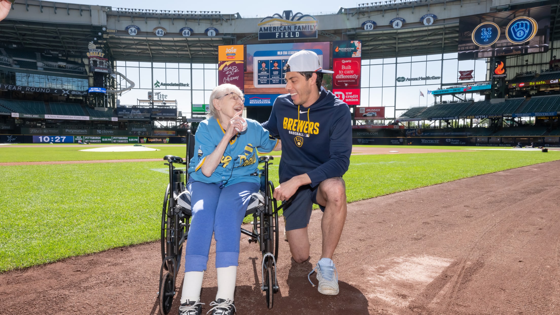 Christian Yelich and a fan are all smiles as they take a picture on the field at American Family Field.