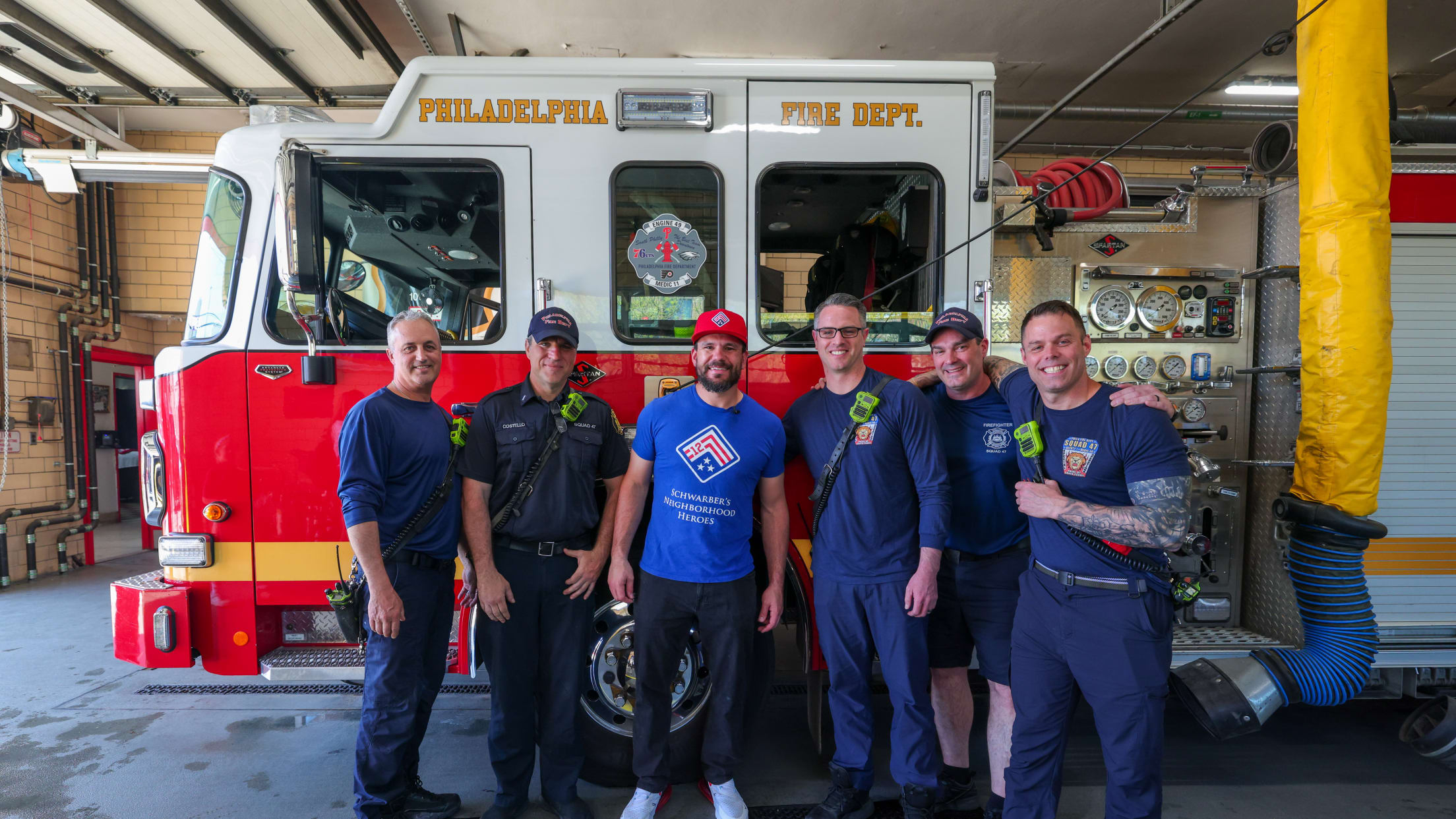 Kyle Schwarber takes a photo with the firefighters of Engine 11 at their firehouse in Philadelphia, Pa.