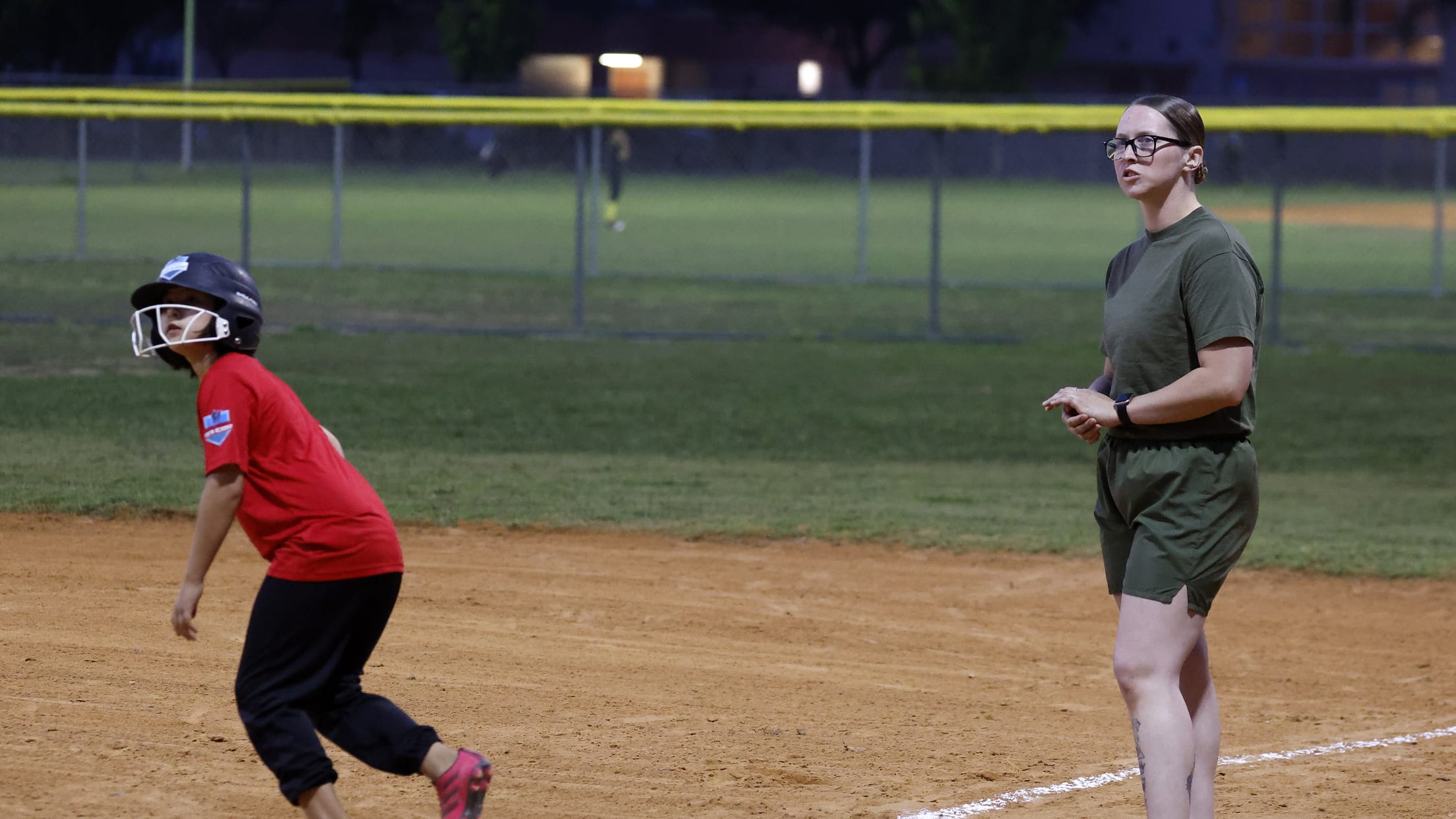 The first base coach and the player look in the air.