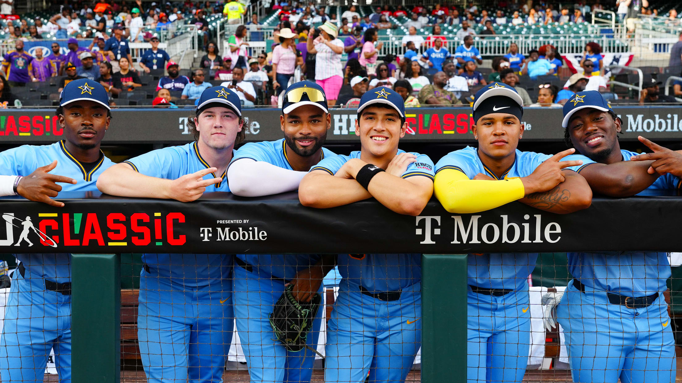 Players in the HBCU Swingman Classic pose with smiles for camera from the Truist Park dugout.