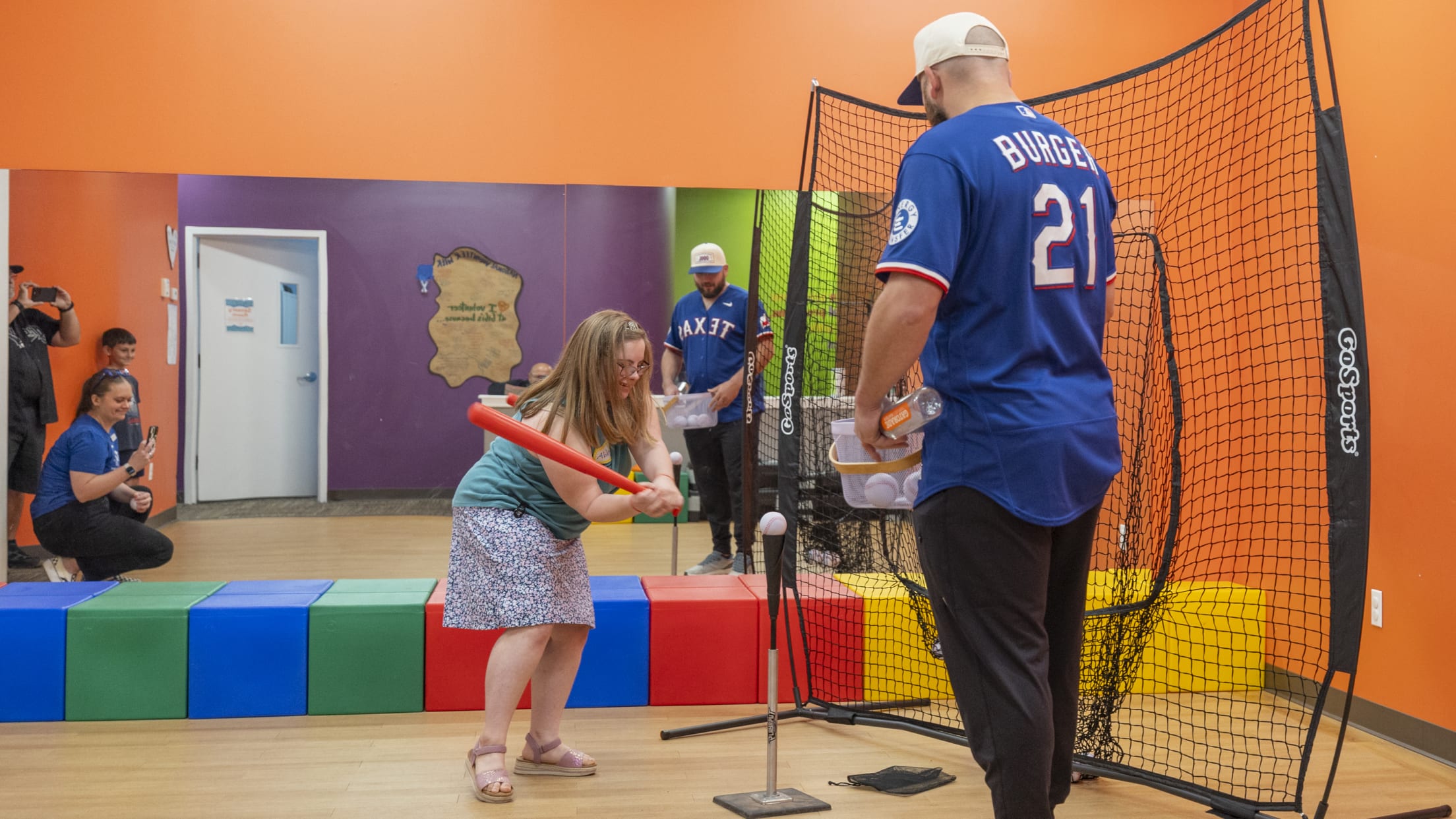 Jake Burger plays t-ball with a girl at Gigi's Playhouse.
