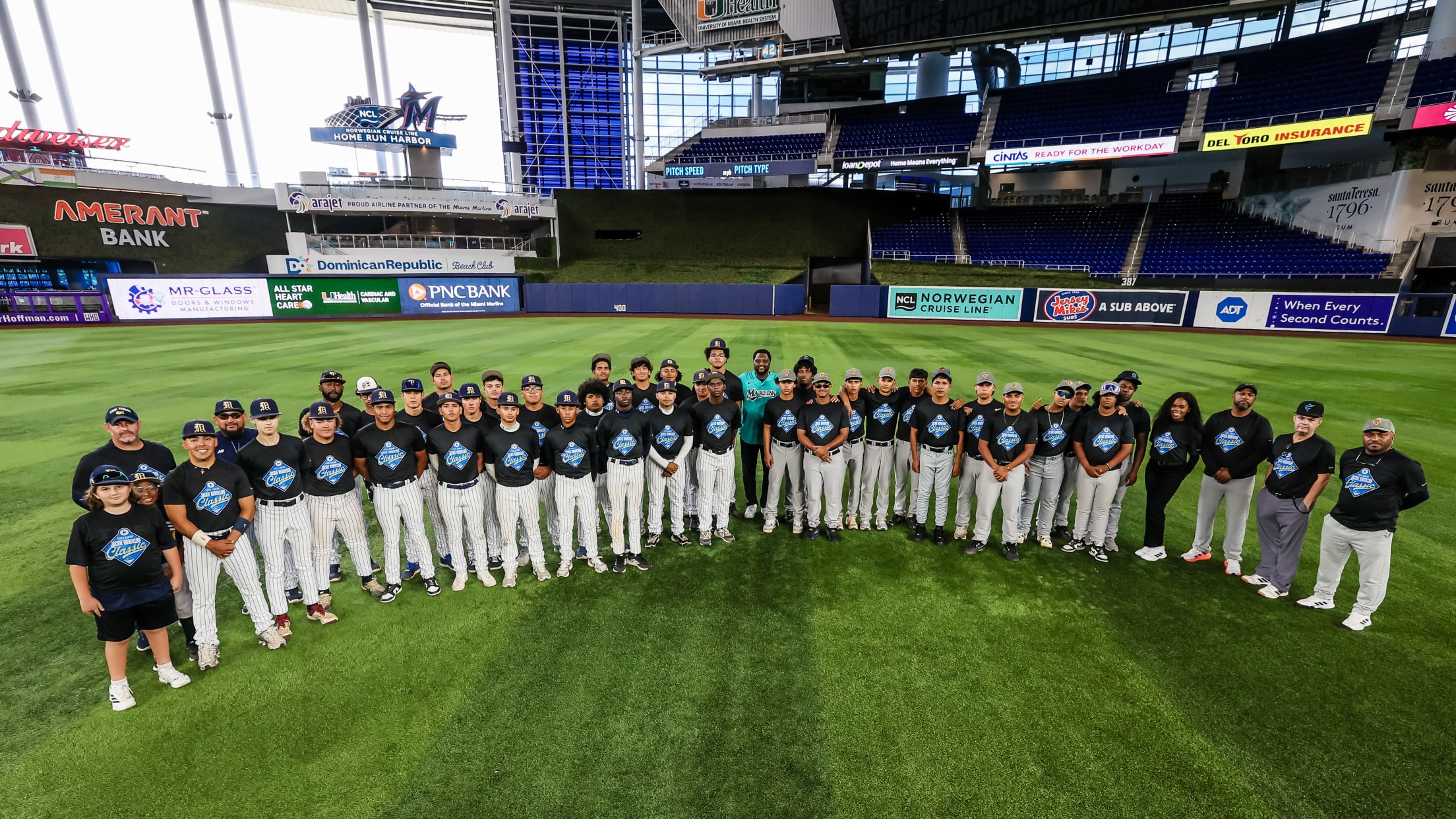 Players pose for a group photo in the outfield at the Jackie Robinson Classic.