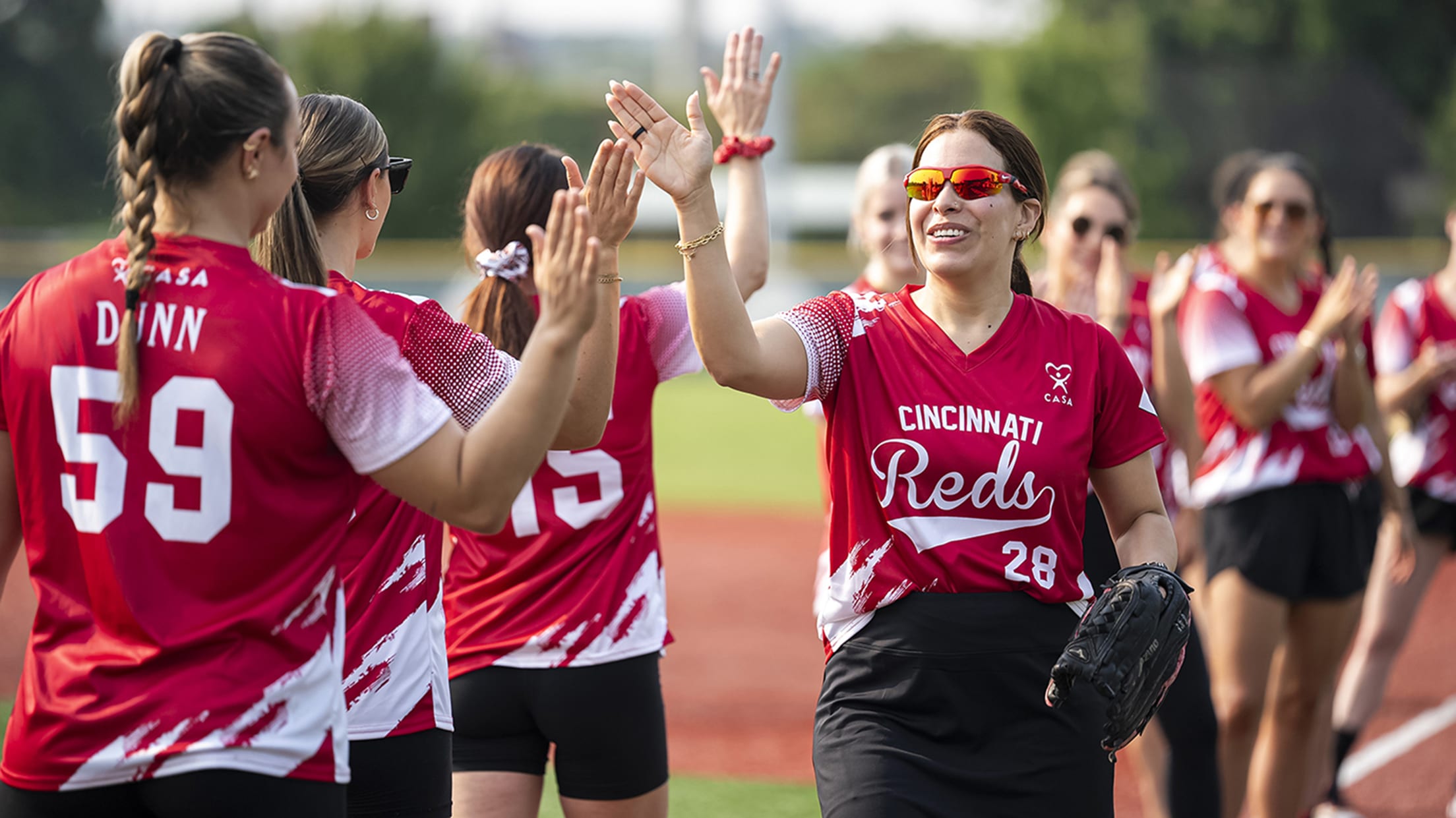 Reds wives high-fiving before they run out to their position.
