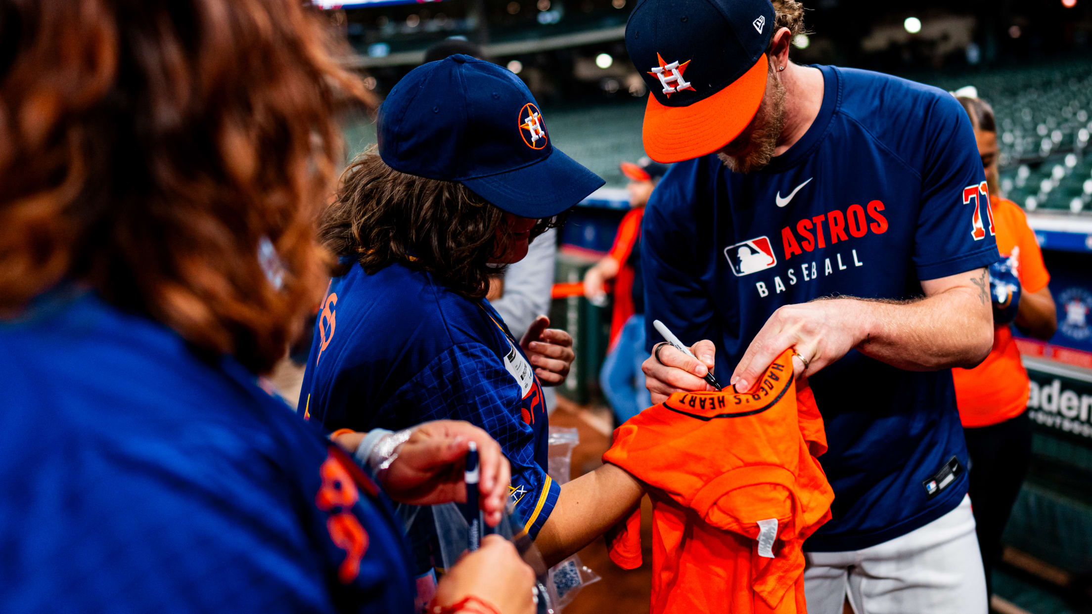 Josh Hader signs a shirt for a Houston Astros fan.