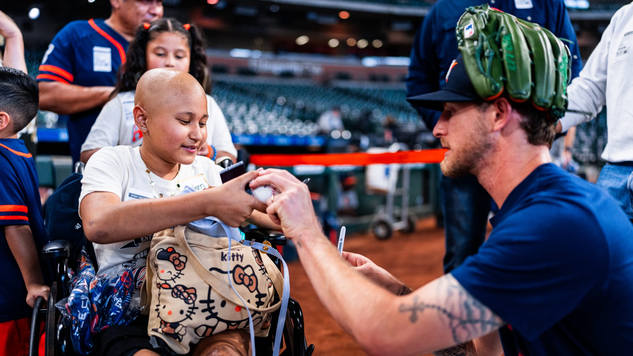 Josh Hader signs a baseball for a young fan at Daikin Park.