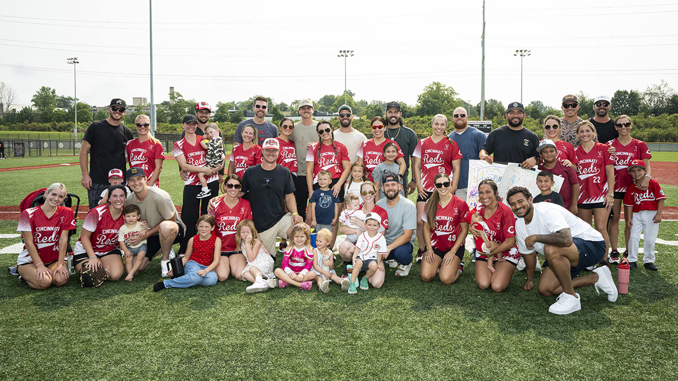 Reds players, their wives and their kids after the softball game.