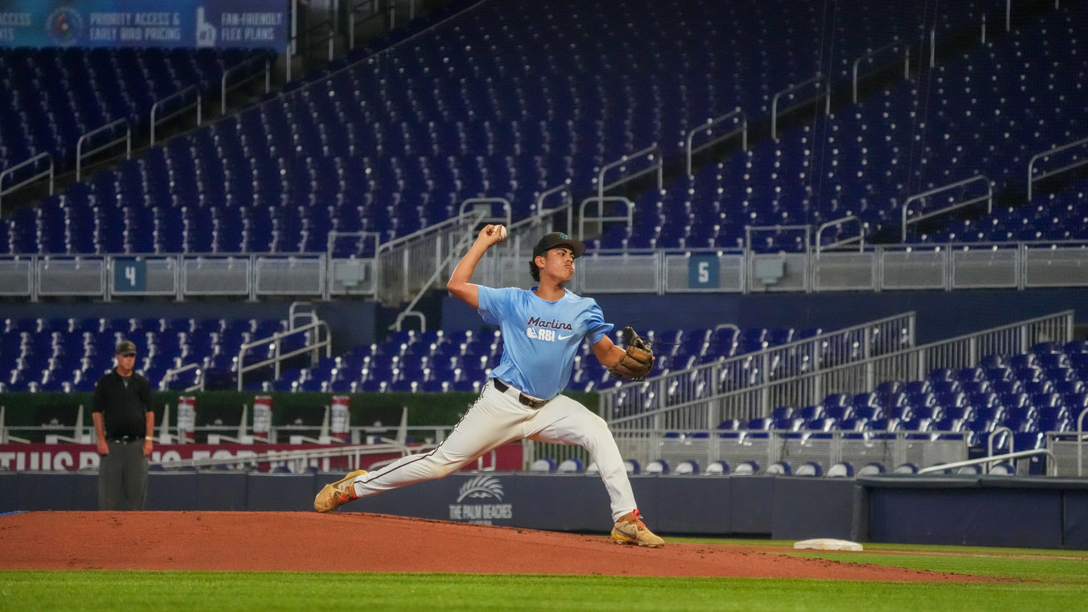 A pitcher lunges from the pitcher's mound toward home plate at they prepare to throw the ball.