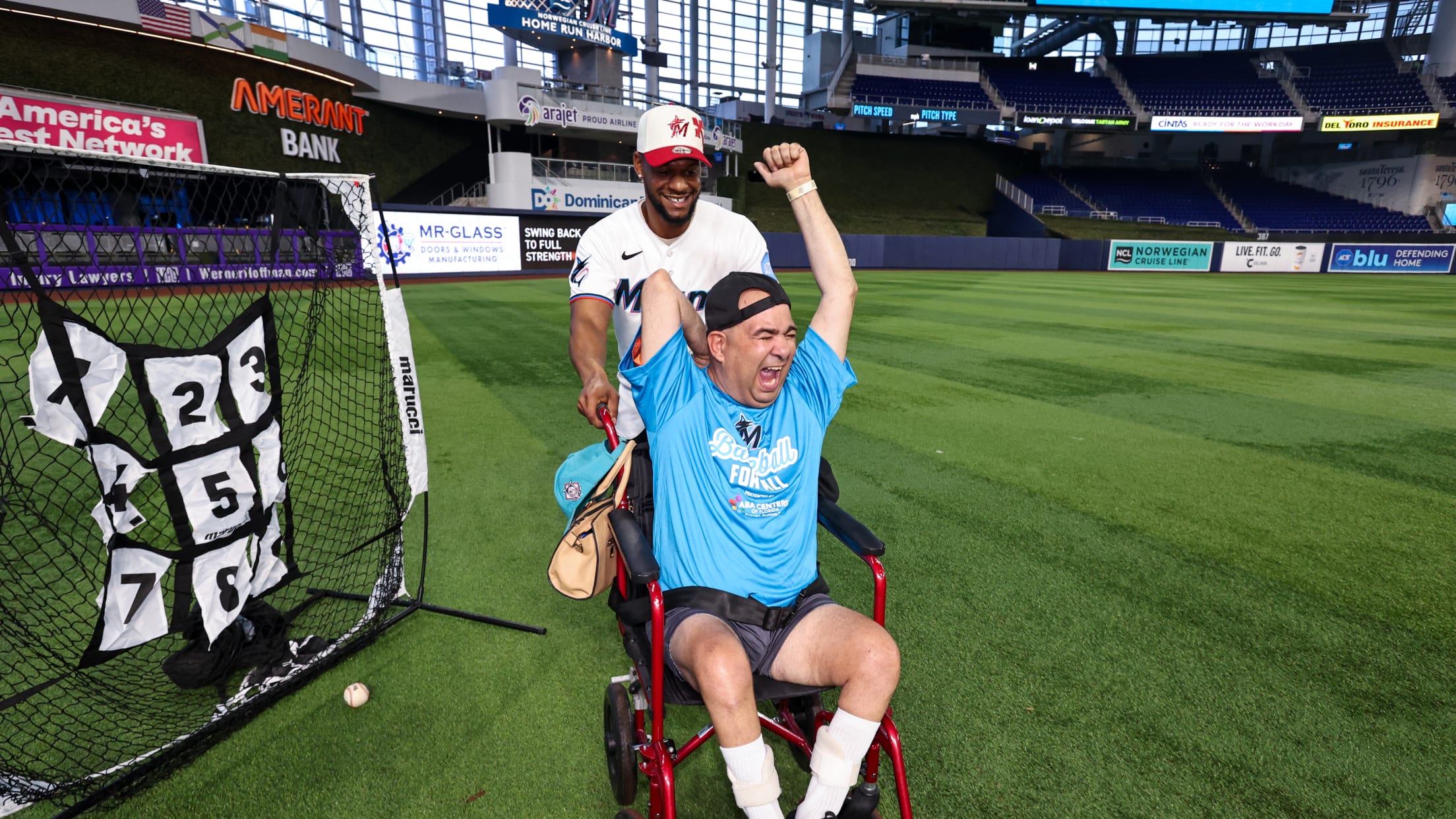 Otto Lopez with an excited fan as they partake in Baseball Fantasy Camp at loanDepot Park.
