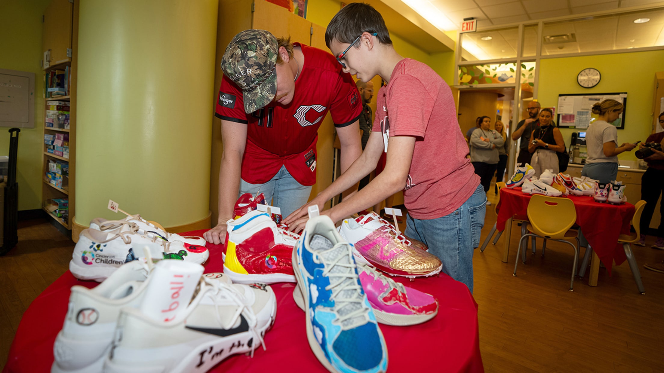 Andrew Abbott admiring a table of cleats with a patient.