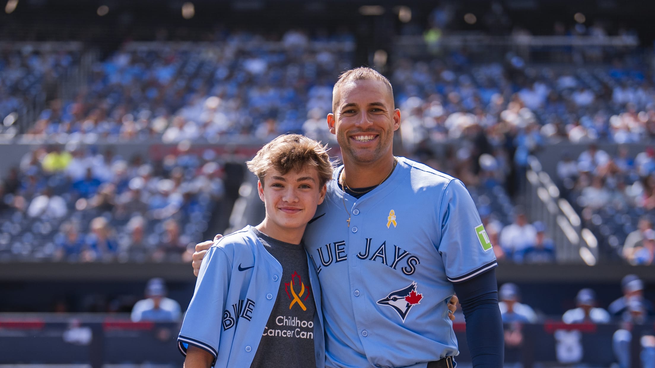 George Springer takes a picture with a kid from Childhood Cancer Canada.