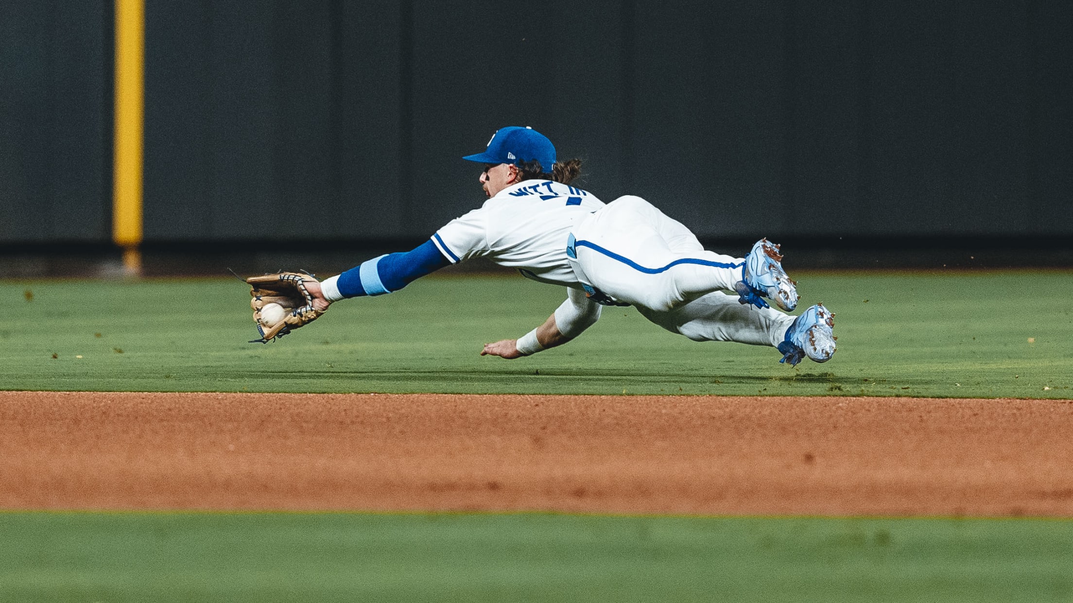 Bobby Witt Jr. makes a diving play in the infield during a game against the Texas Rangers at Kauffman Stadium.