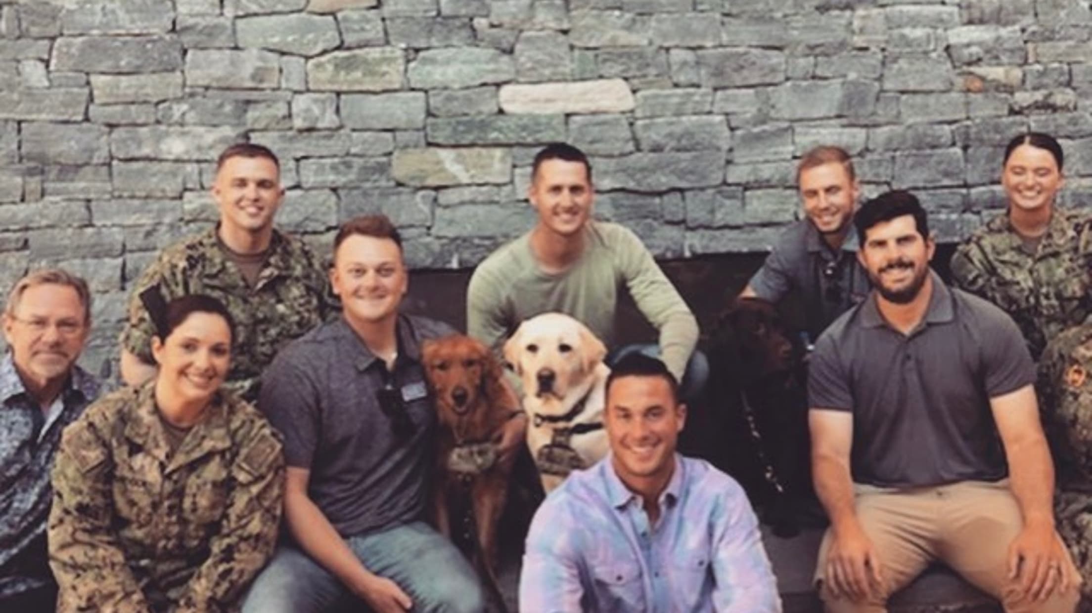 Carlos Rodón, two dogs and members of the military pose for a photo.